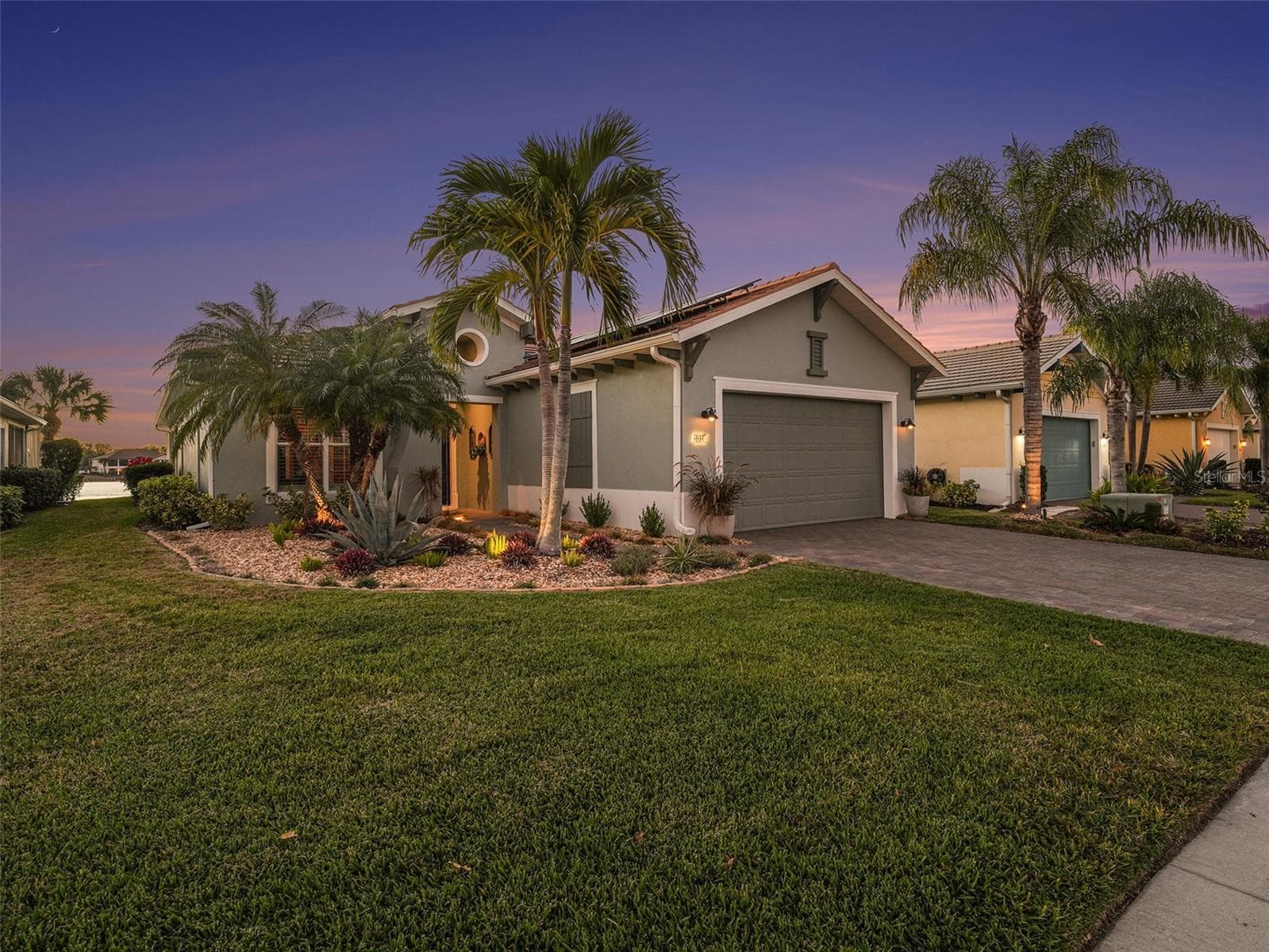 Front exterior with lush lawn, mature palms, and inviting curb appeal in a beautifully maintained setting. - 1018 OVERLOOK CT, BRADENTON