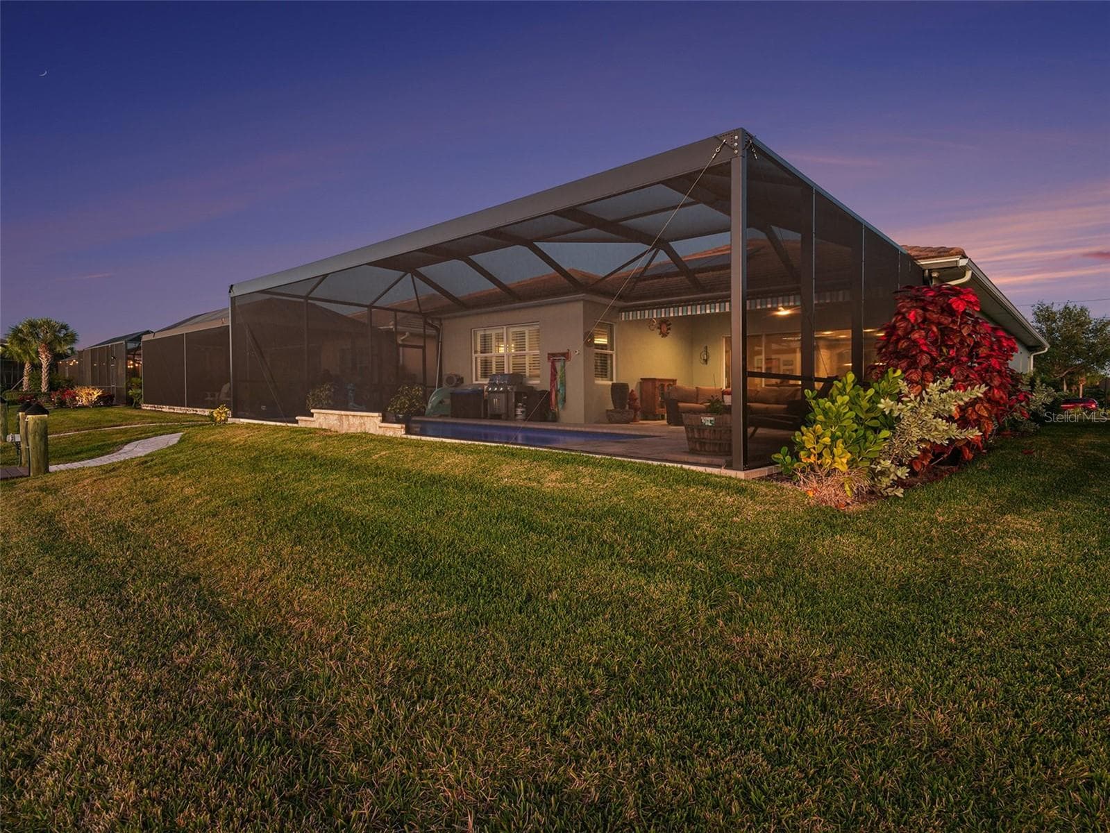 Rear exterior view highlighting the expansive screened lanai, waterfront setting, and beautifully designed outdoor living spaces. - 1018 OVERLOOK CT, BRADENTON