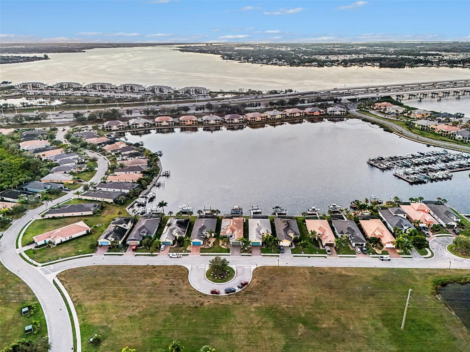 Overhead view of the waterfront neighborhood with beautifully arranged homes, lakes, and nearby boating access. - 1018 OVERLOOK CT, BRADENTON