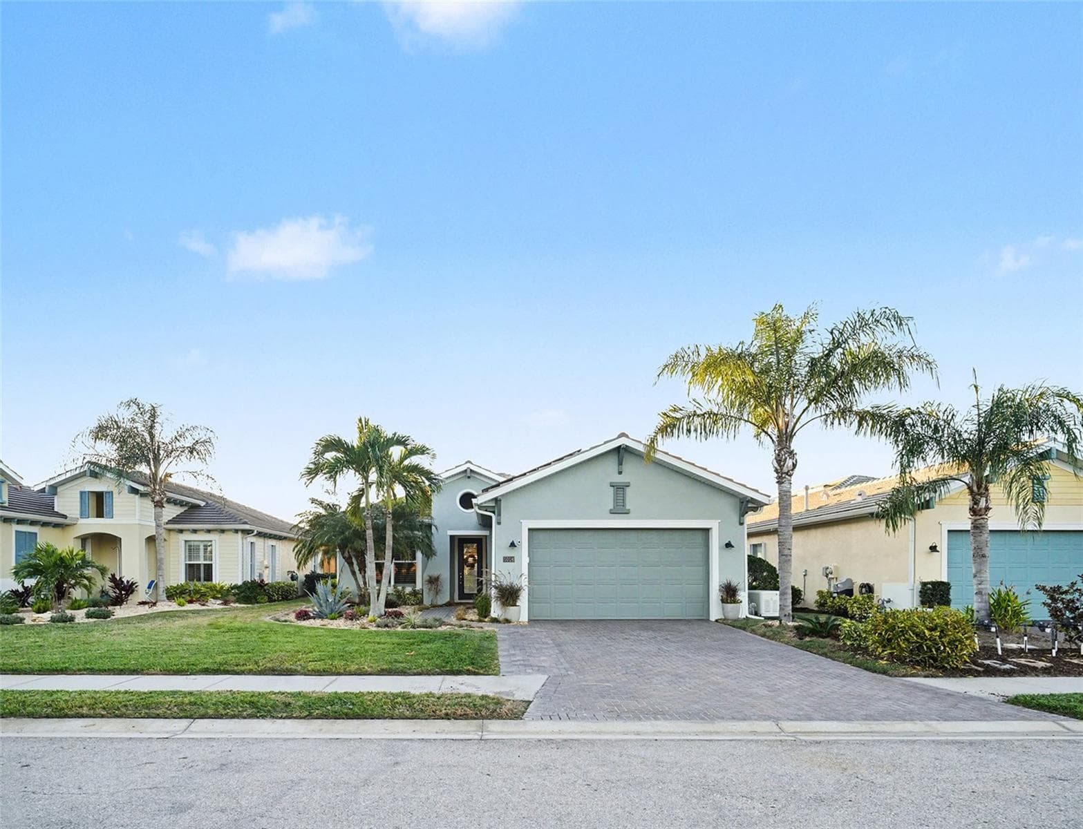 Street view of the front exterior featuring mature palms, attractive landscaping, and a clean, inviting presentation. - 1018 OVERLOOK CT, BRADENTON