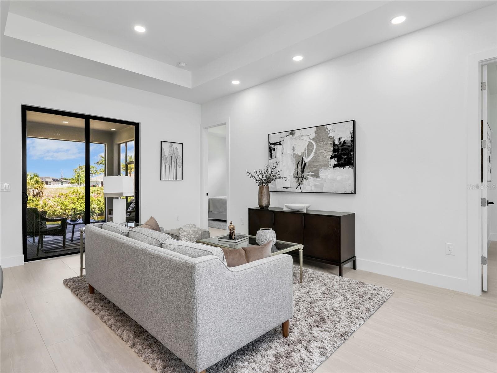 Living area featuring recessed lighting, a tray ceiling, and light wood-finish flooring photos used from another listing to show what it would look like with furniture - 1310 NW 11TH TER, CAPE CORAL