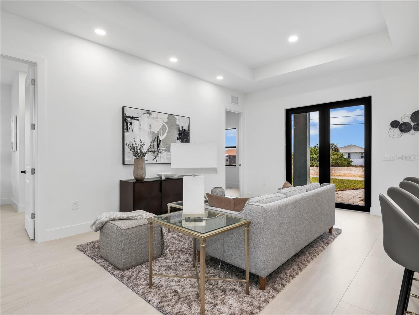 Spacious living area featuring light-toned looring, recessed lighting, and a tray ceiling photos used from another listing to show what it would look like with furniture - 1310 NW 11TH TER, CAPE CORAL