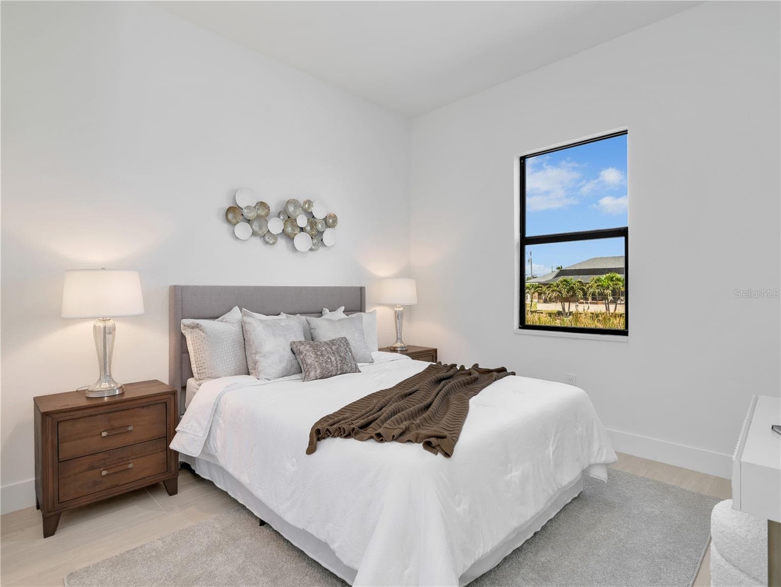 Bright bedroom featuring light wood-finish flooring and a single rectangular window photos used from another listing to show what it would look like with furniture - 1310 NW 11TH TER, CAPE CORAL
