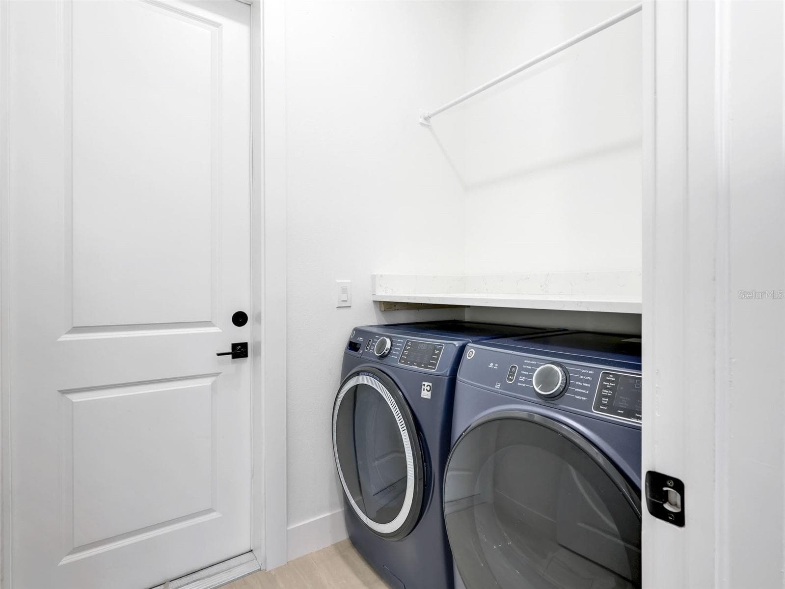 Laundry room featuring a built in shelf hanging rod and light colored flooring - 1310 NW 11TH TER, CAPE CORAL