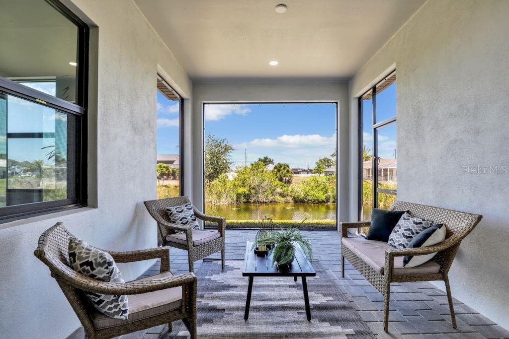 Covered patio featuring a large rectangular opening to the outdoors, a water feature, and a paved flooring surface photos used from another listing to show what it would look like with furniture - 1310 NW 11TH TER, CAPE CORAL