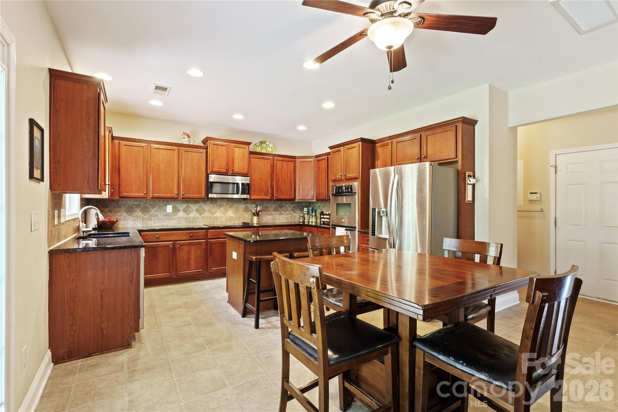 Kitchen with Cherry Cabinets, Backsplash, SS Appls, and Center Island. - 8458 Mossy Cup Trail, Harrisburg