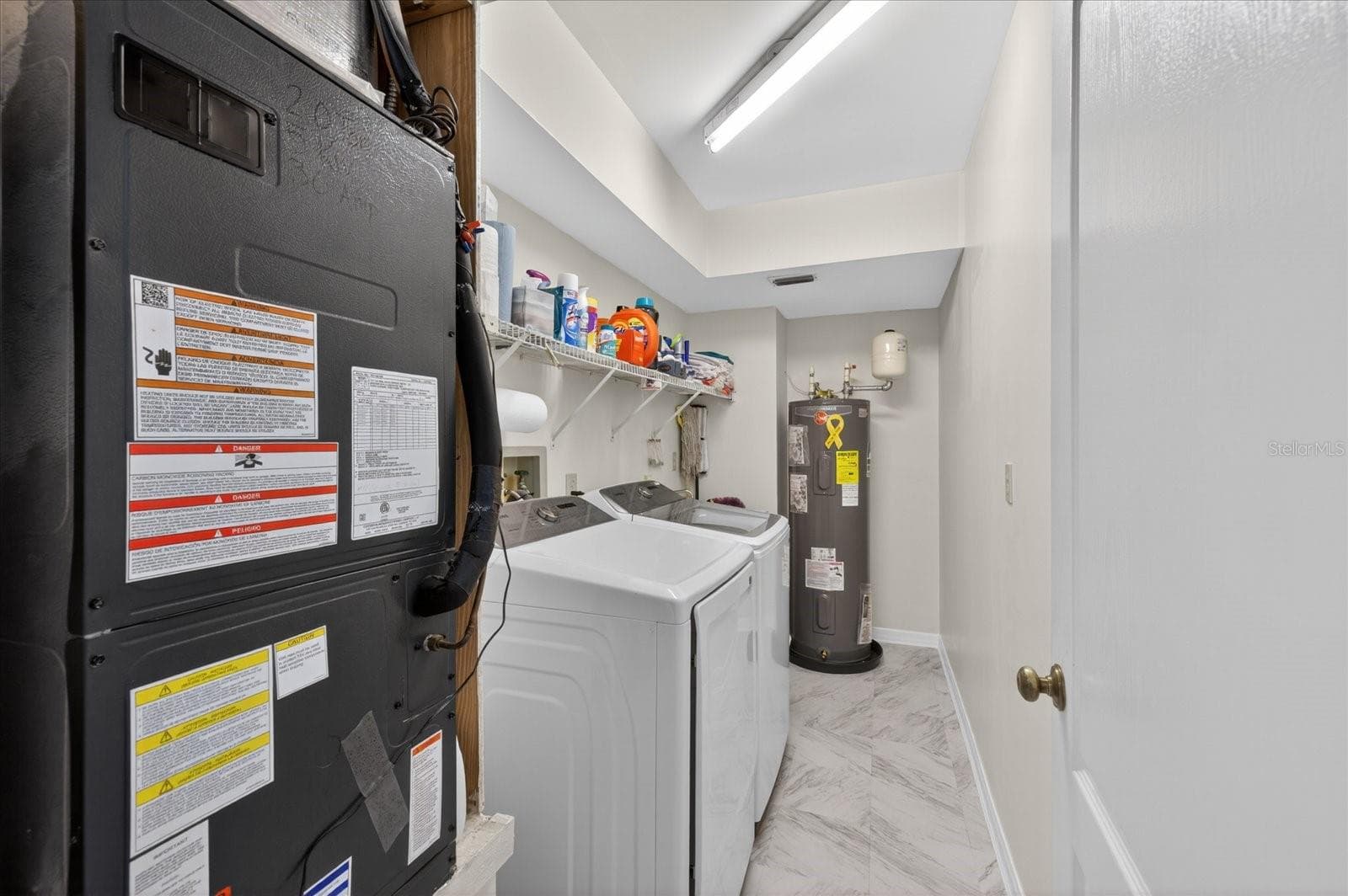Laudry room with air handler for lower level and hot water heater - 4340 SEAGULL DR, NEW PORT RICHEY