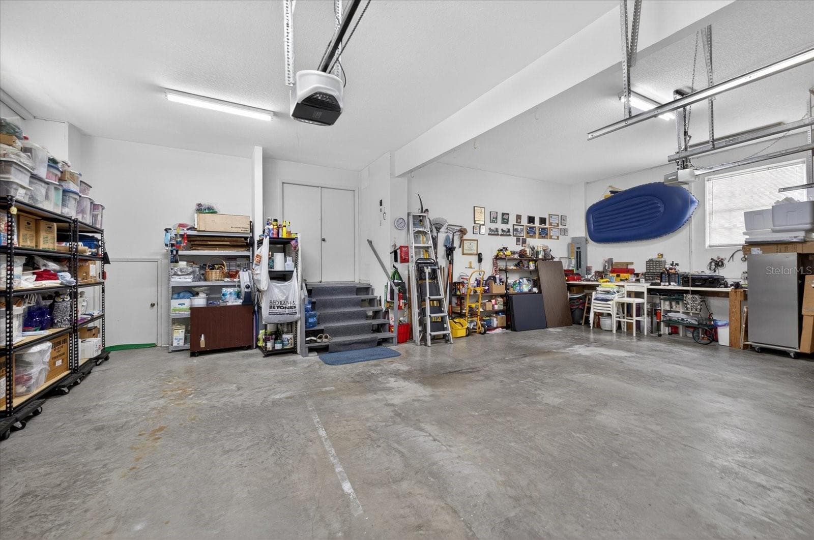 Garage with closet under stairs for water softener system storage and more! - 4340 SEAGULL DR, NEW PORT RICHEY