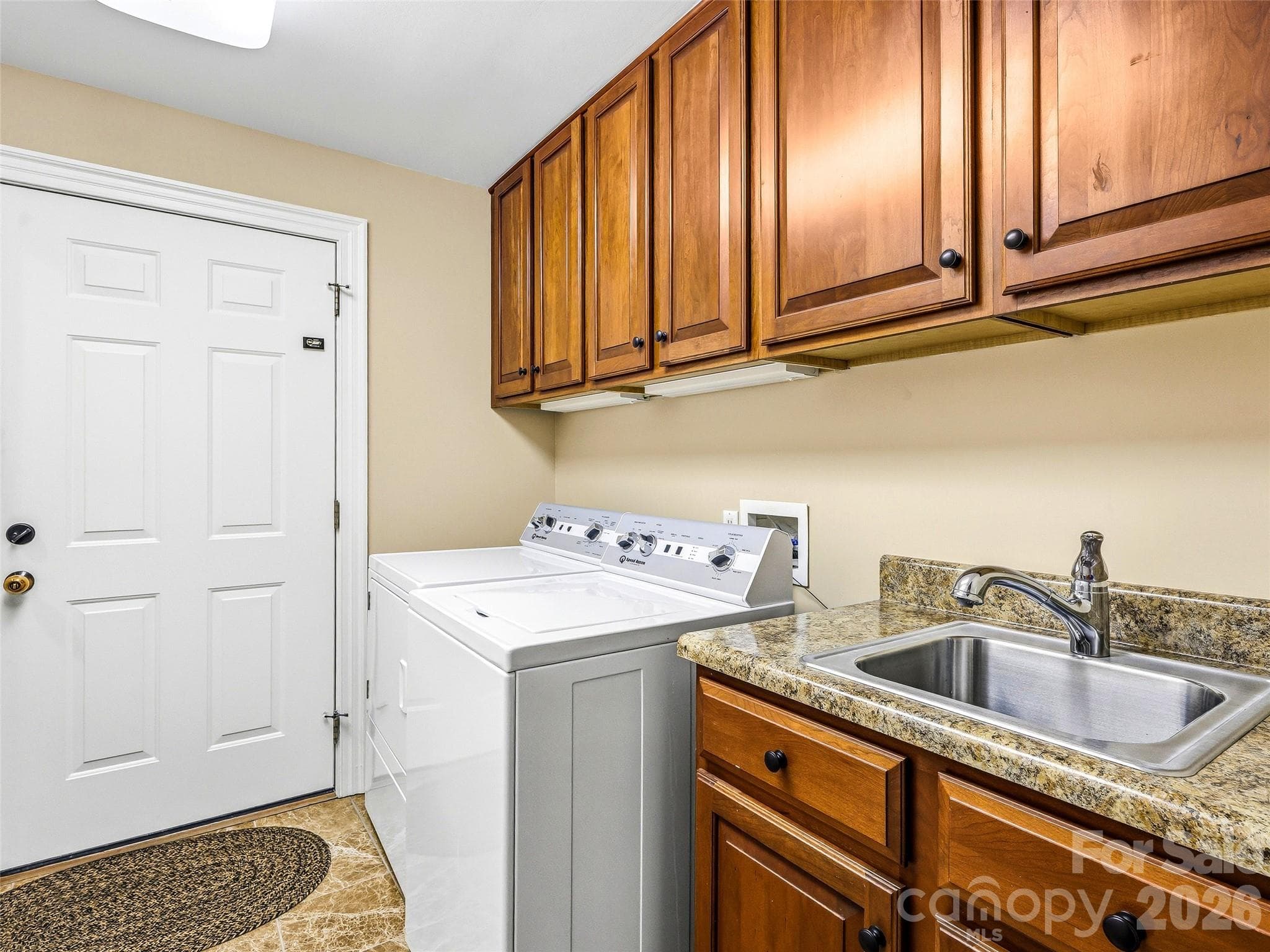 The main level laundry room has plentiful storage and a convenient sink. The washer/dryer stay with the home. - 33 Tiverton Lane, Asheville