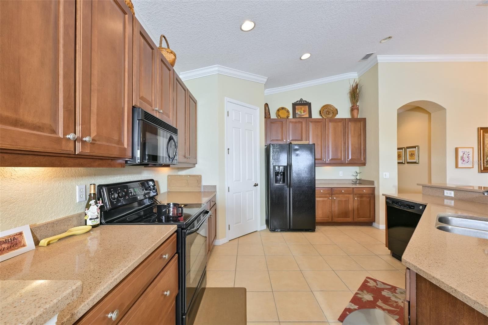 Upgraded kitchen cabinets w/solid surface counters. Tile flooring throughout and crown molding - 1330 EMERALD DUNES DR, SUN CITY CENTER