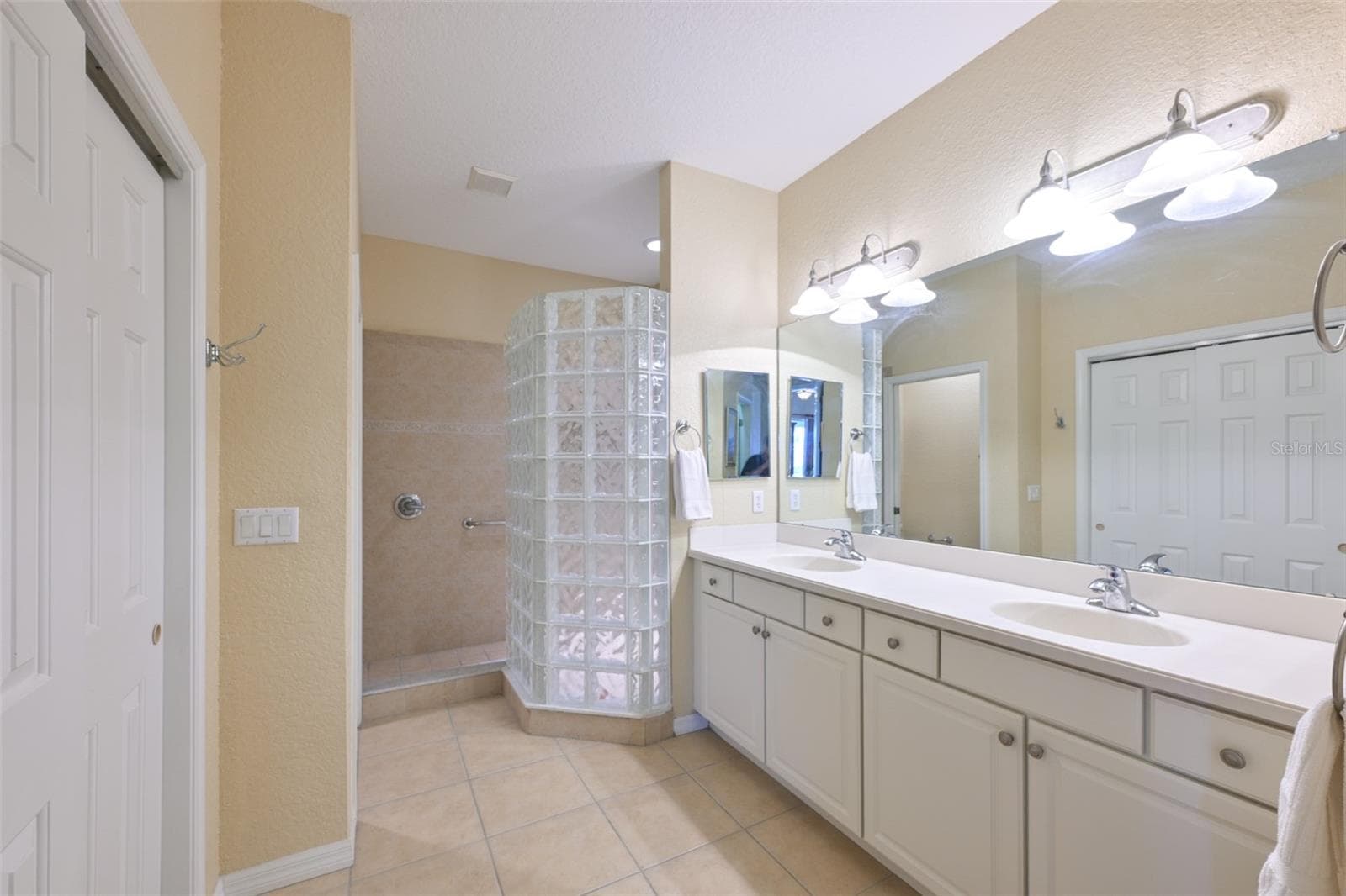 Main bathroom ensuite with raised double sink vanity and walk in shower. - 1330 EMERALD DUNES DR, SUN CITY CENTER