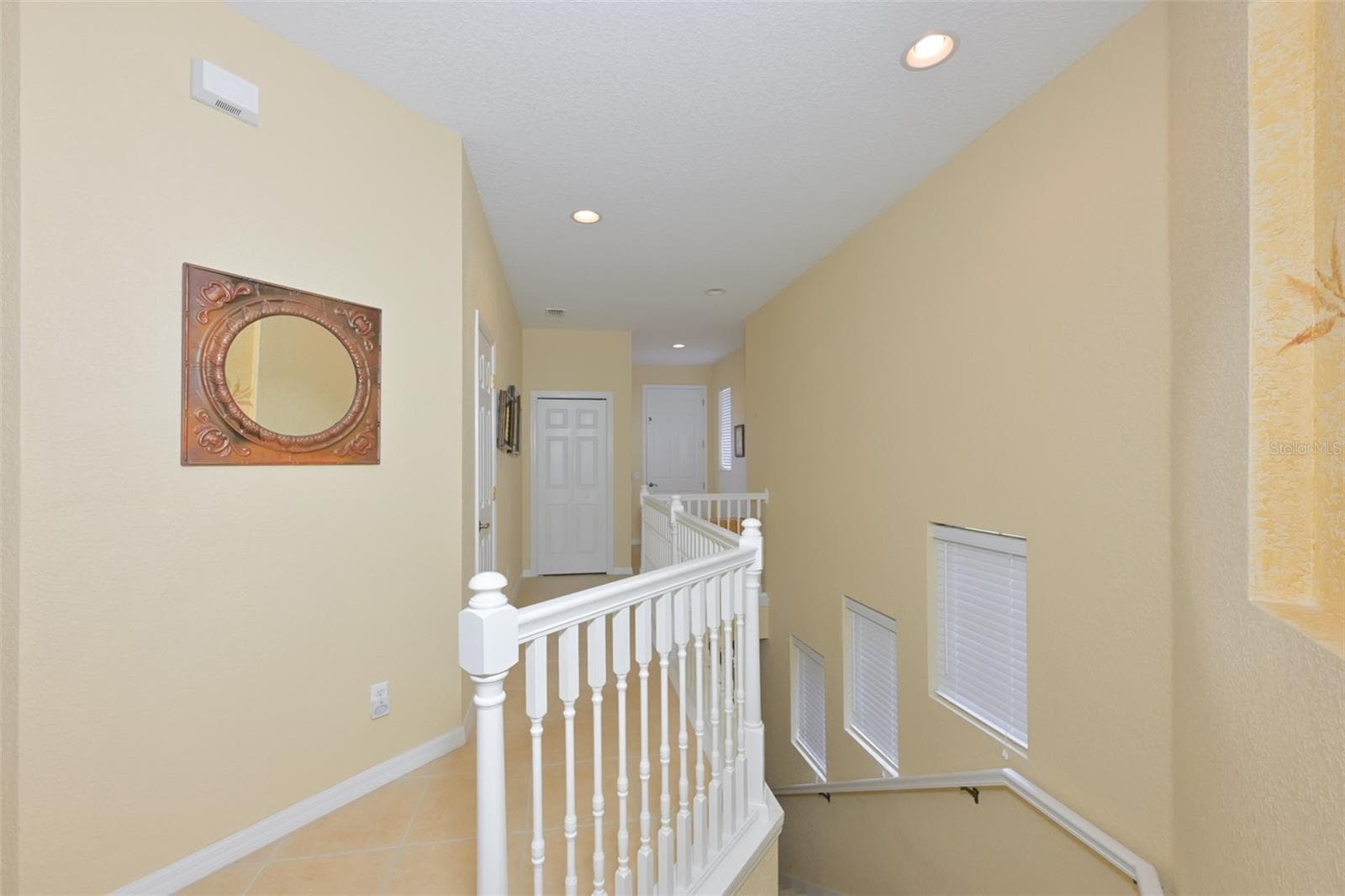 View coming up the stairs looing down the way to the elevator. - 1330 EMERALD DUNES DR, SUN CITY CENTER