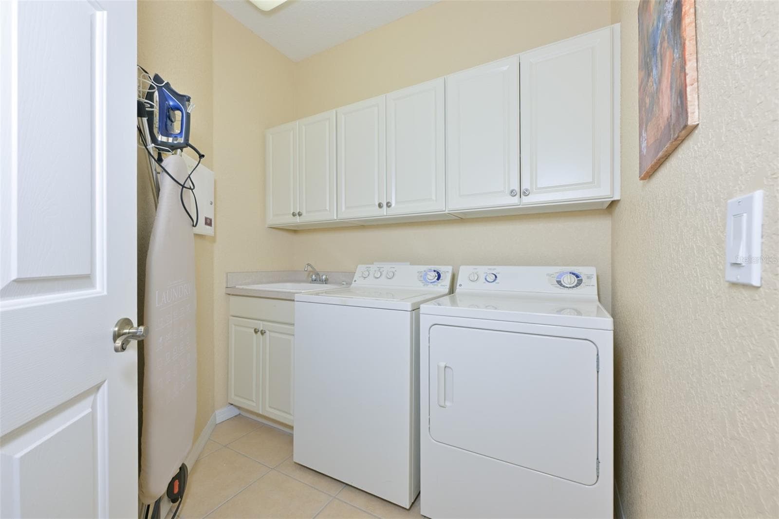 Laundry room with extra cabinets and sink. - 1330 EMERALD DUNES DR, SUN CITY CENTER