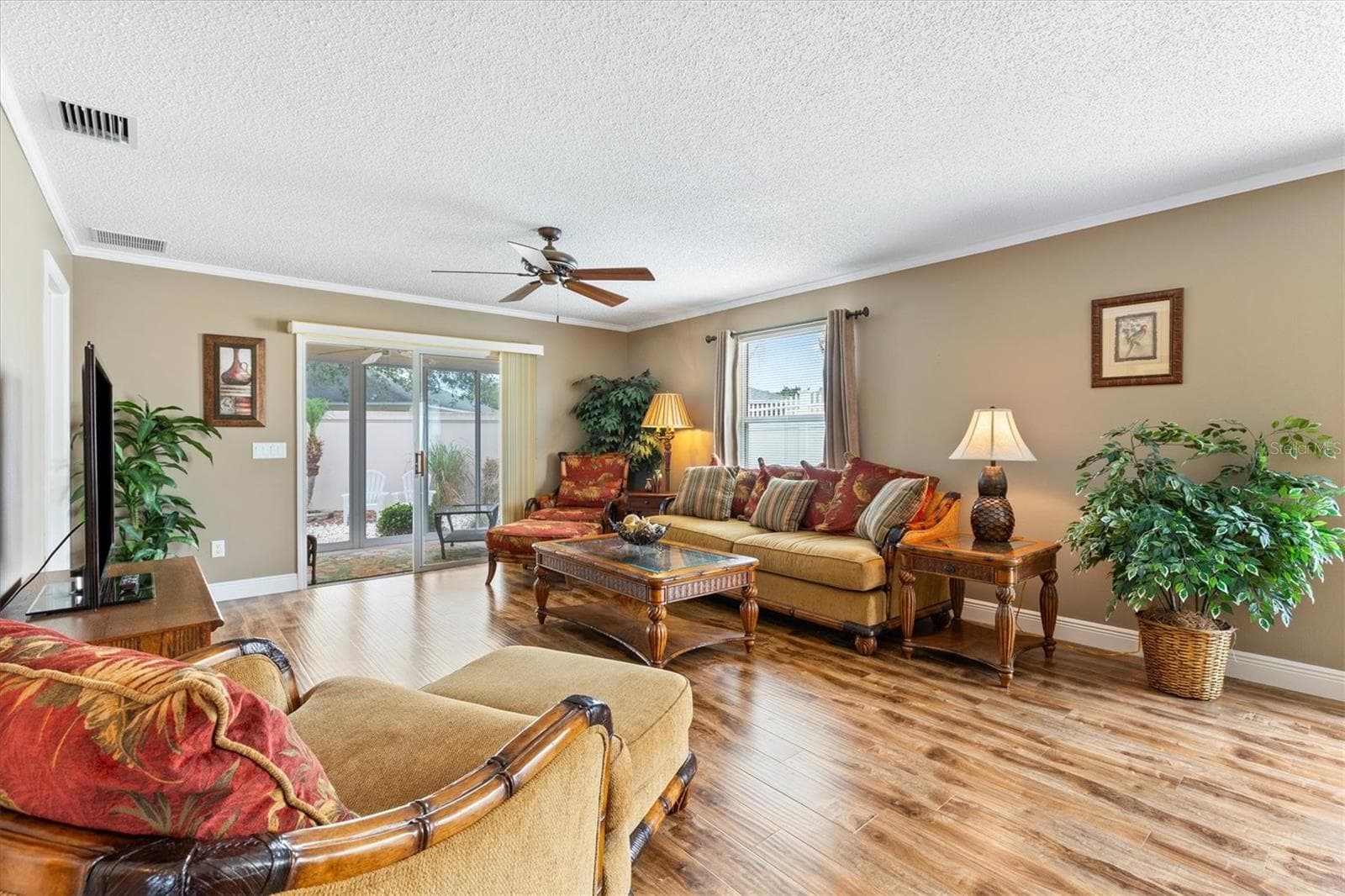 LIVING ROOM LOOKING TOWARDS BACK ENCLOSED LANAI - 979 SMYRNA ST, THE VILLAGES
