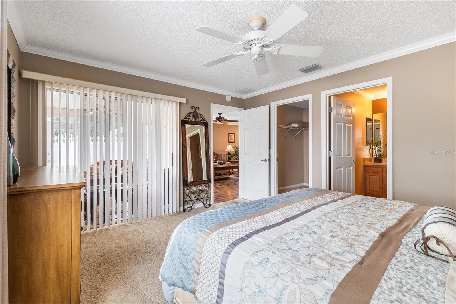 PRIMARY BEDROOM LOOKING TOWARDS BATH, WALK IN CLOSET AND LANAI - 979 SMYRNA ST, THE VILLAGES