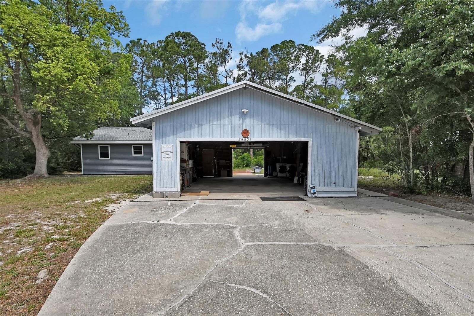 Front view showing garage and home behind - 25801 BLUE LAKES DR, PAISLEY