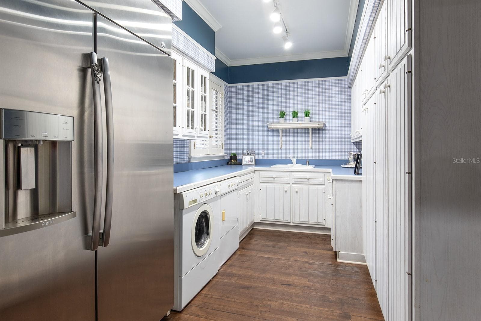 Look at the size of this laundry room! Situated off the corridor of the side entrance.  Equipped with an additional refrigerator, load of cabinetry and plenty of counter space for folding clothes and storage. - 1351 N CLASSIC CT, LONGWOOD