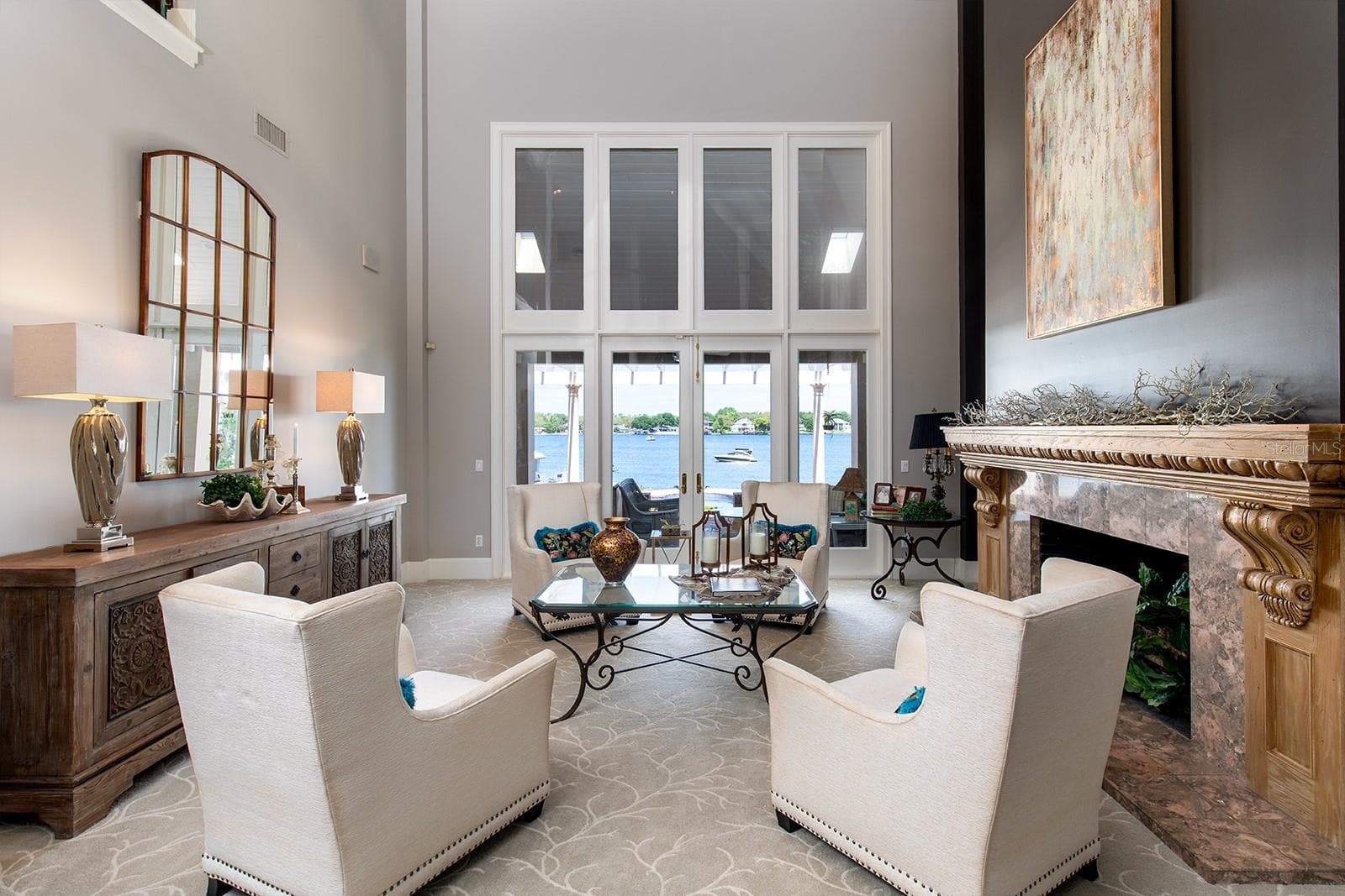 Formal living room is stately and impressive with its marble fireplace and hand carved mantel and panoramic water views that welcome the outside in. - 1351 N CLASSIC CT, LONGWOOD