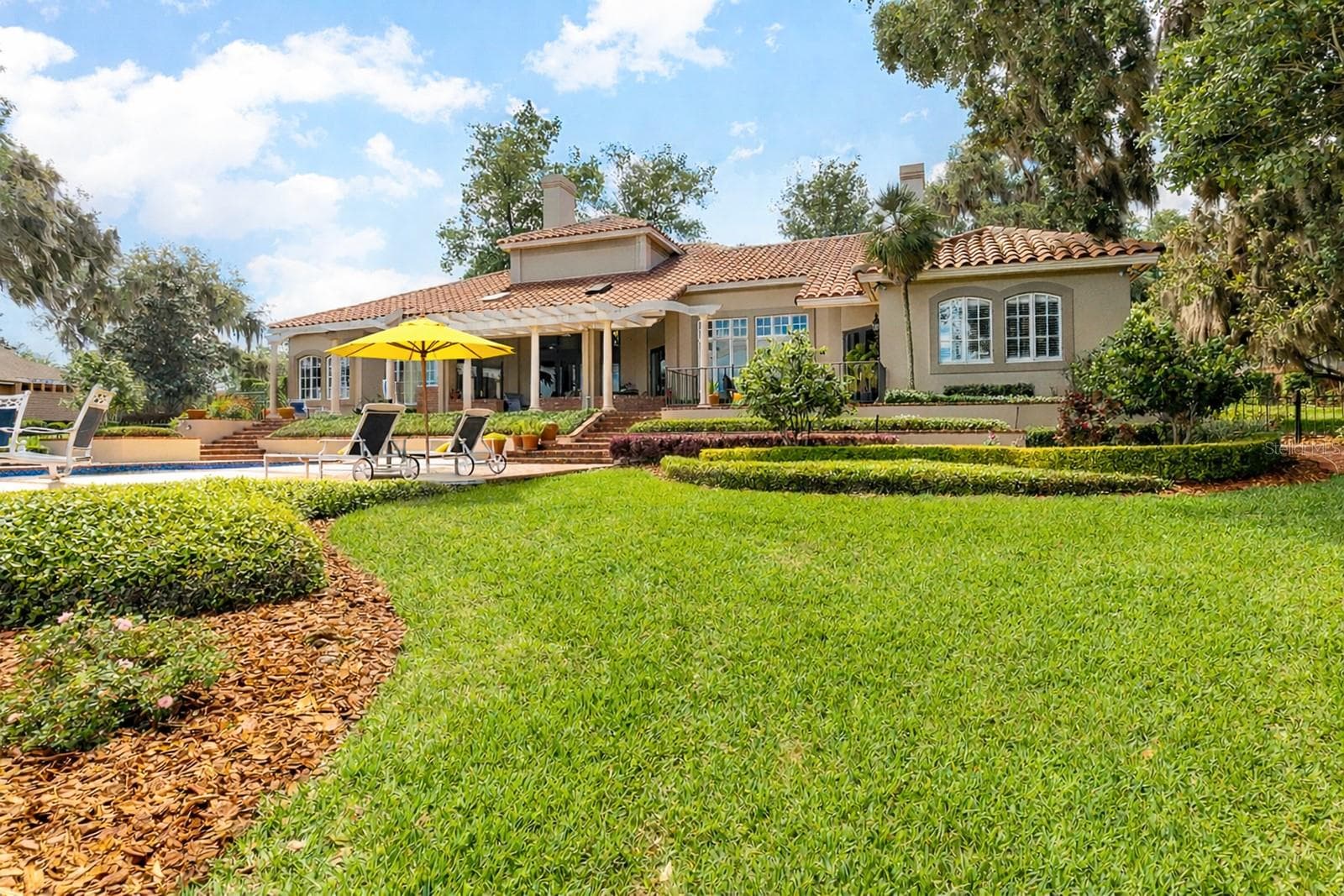 Experience your LAKESIDE LEGACY with 4-5 bedrooms, 5.5 baths pool home, three-car garage, porte-cochere, pool and spa, boathouse and dock, plus bonus flex space in the basement—ideal for a workout room or wine tasting cellar. - 1351 N CLASSIC CT, LONGWOOD