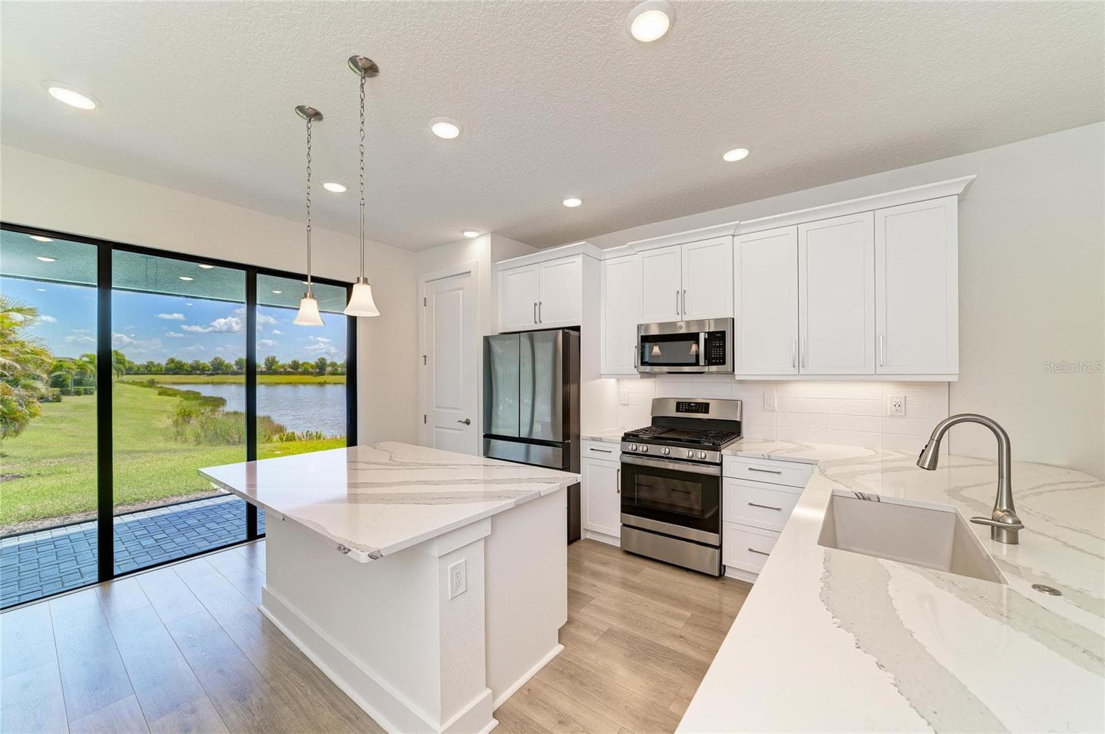 Kitchen with upgraded cabinets and view - 5290 BARNETT CIR, BRADENTON