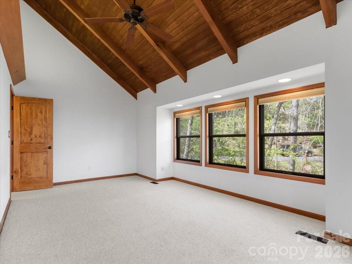 Primary bedroom with exposed beams, wall of windows and vaulted ceilings - 49 Slickrock Ridge Way S, Burnsville