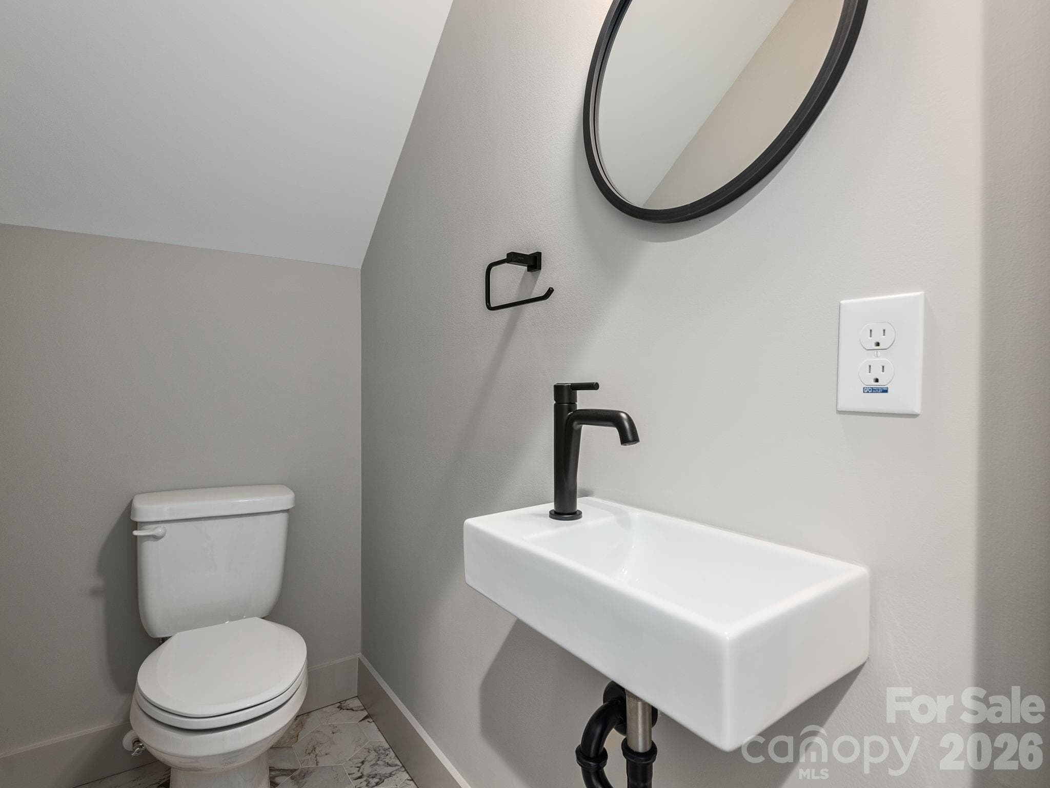 Representative photo from 50 Verde Drive showing the builder’s quality of construction and finish level, including a lower-level half bath with pedestal sink, ceramic tile flooring, and clean modern finishes. - Asheville