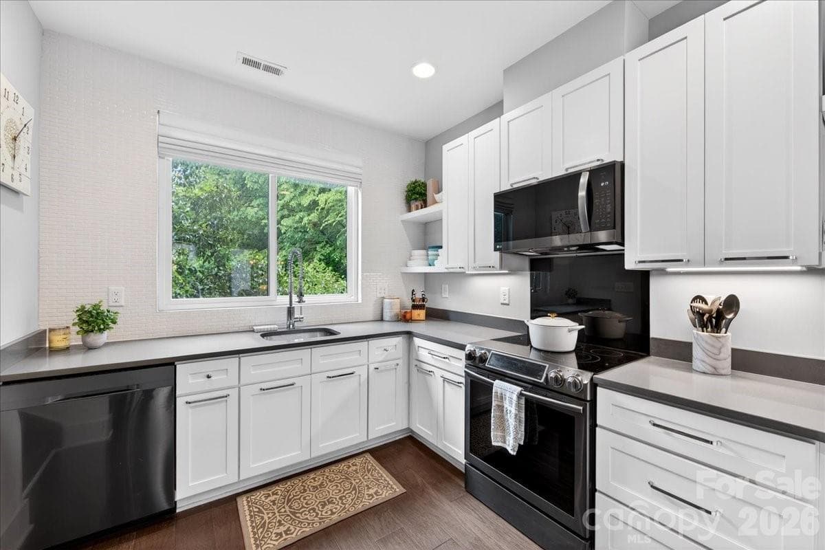 Kitchen with quartz countertops and black stainless appliances - Charlotte