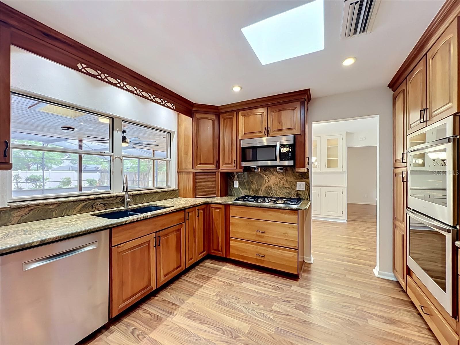Large window keep kitchen light and bright with view of he sparkling pool. - 105 CEDAR OAK TRL, LONGWOOD