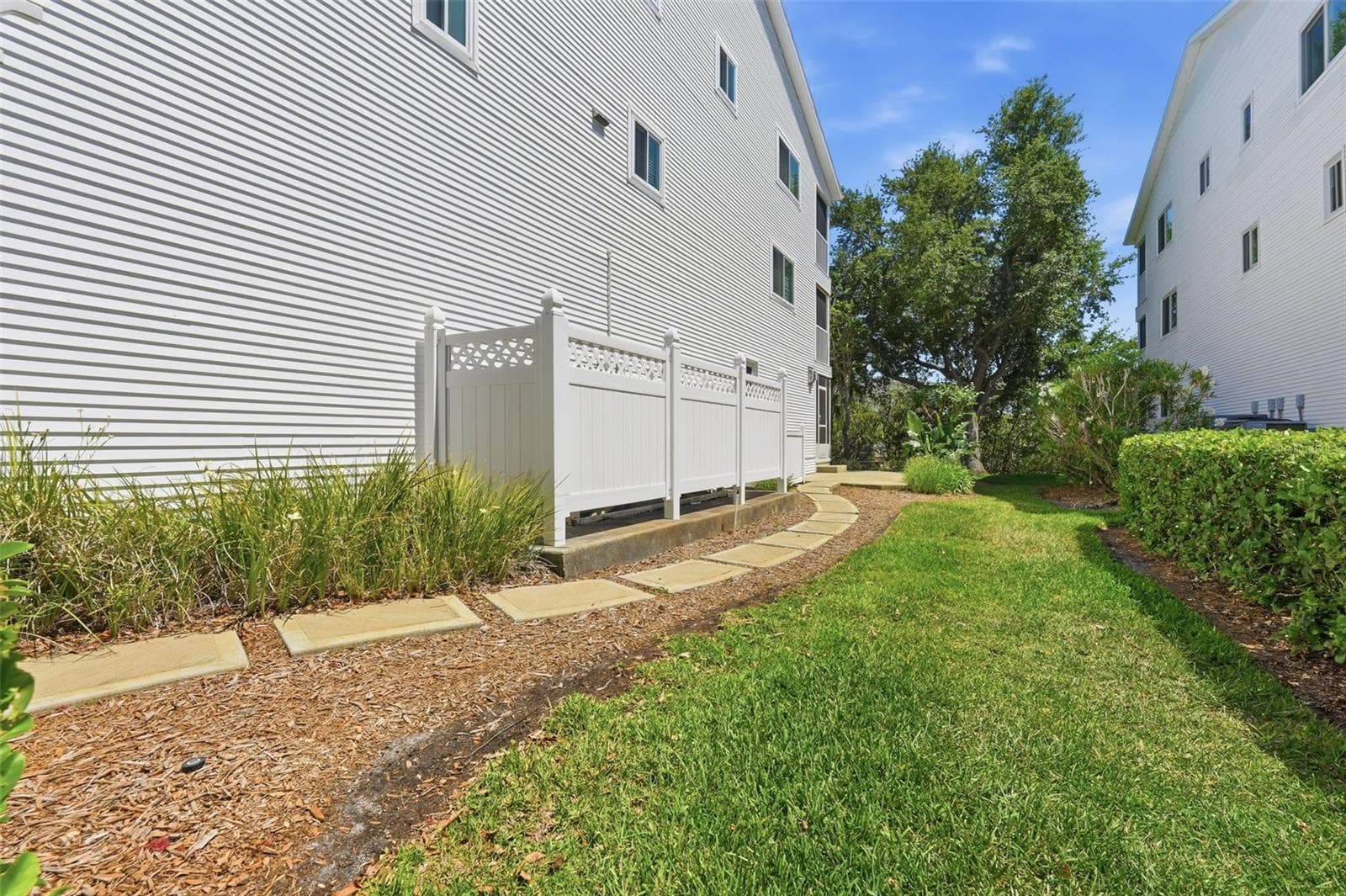 Concrete walkway from driveway to patio. A/C is in the PVC fenced area and Propane tank for this townhome is just past the A/C - 14837 SEMINOLE TRL, SEMINOLE