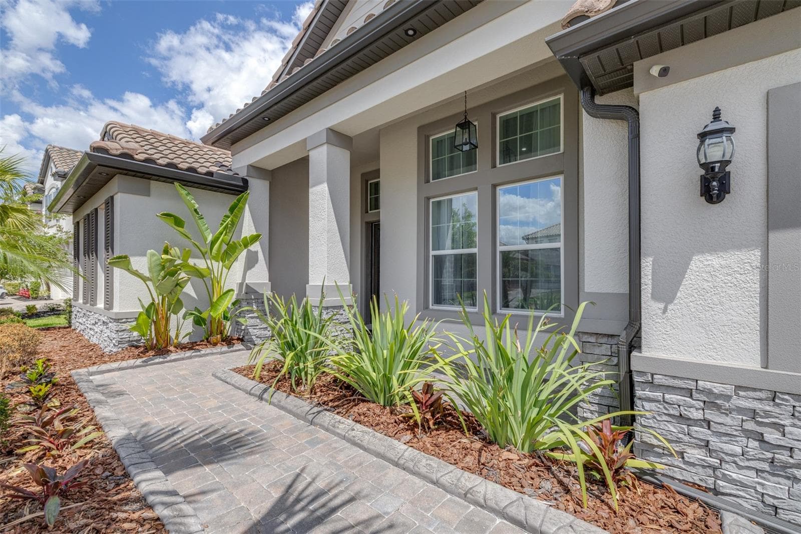 A Welcoming Front Porch overlooks Beautifully-lit Landscaping and the Neighborhood Park - 7190 GRAYBROOK DR, WESLEY CHAPEL