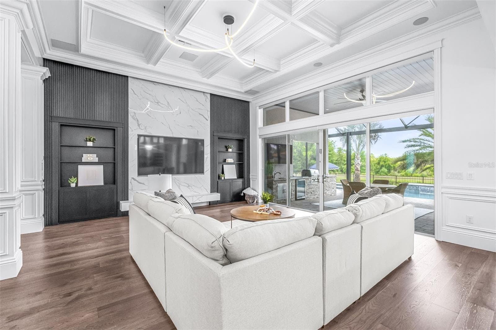 The Entertainment Wall is Accented by Built-in Bookcases, One Side Opening to Reveal the Primary Suite - 7190 GRAYBROOK DR, WESLEY CHAPEL