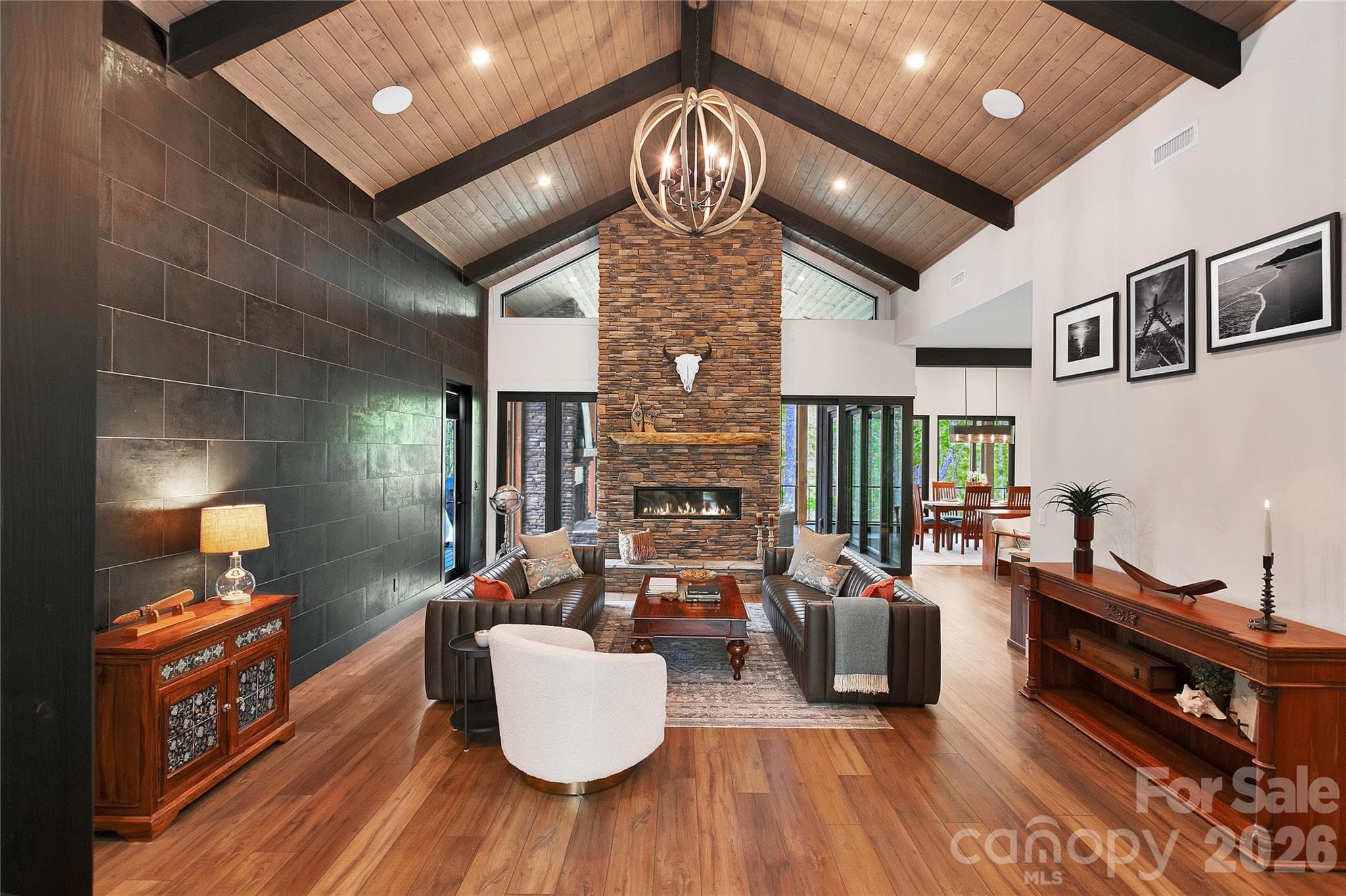 Welcoming grand entrance leads to a beautiful gathering space featuring a stacked stone fireplace and rich wood vaulted ceilings above. - Brevard