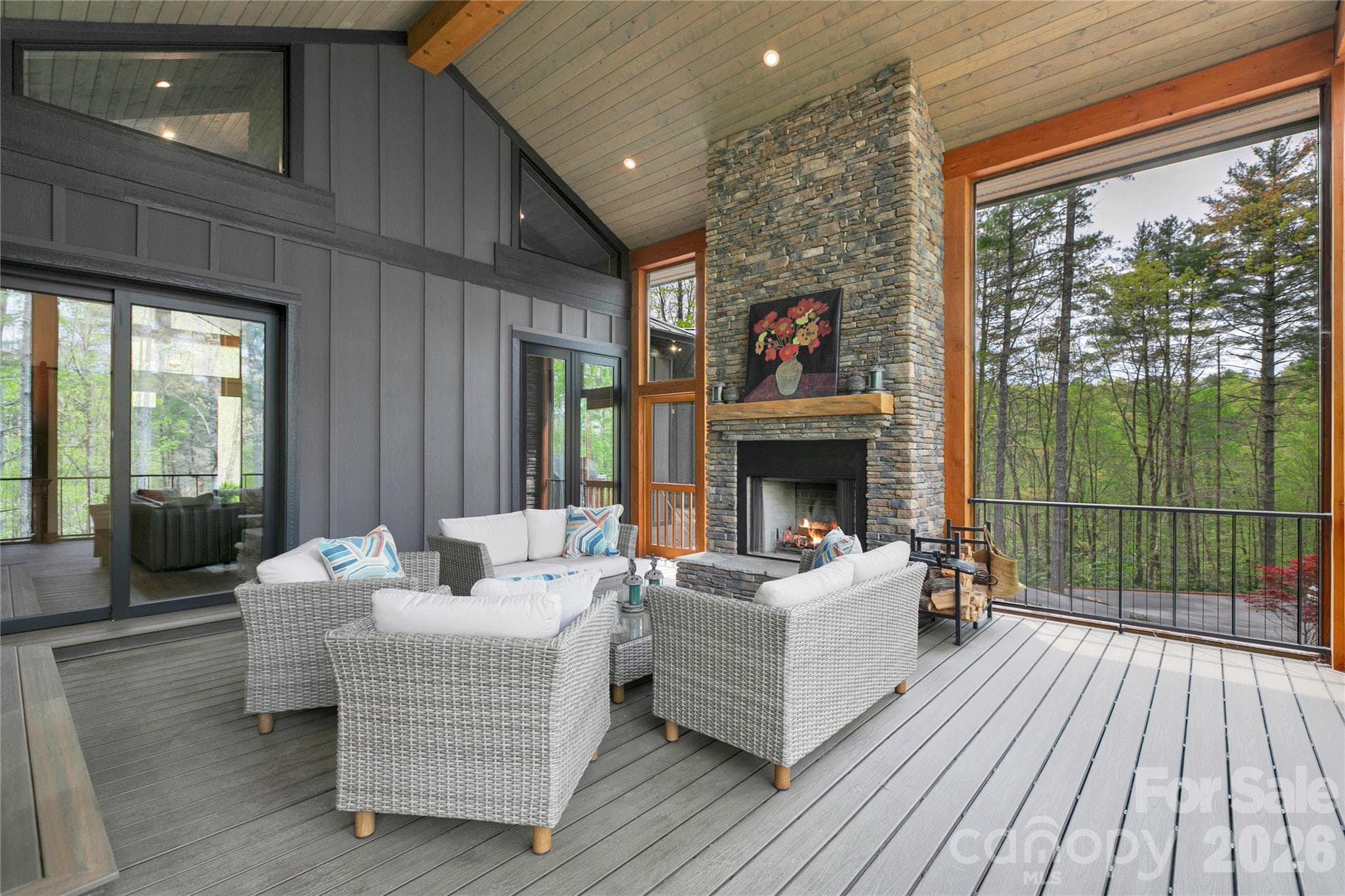 The screen porch serves as a peacful retreat, highlighted by a stacked stone wood burning fireplace that sets the tone for cozy evenings. - Brevard