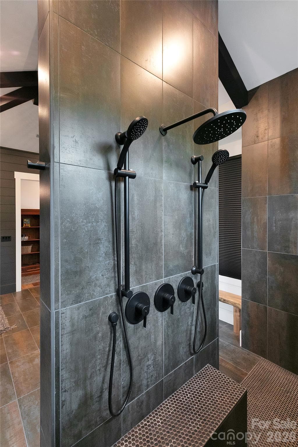The expansive primary shower offers a spa like experience, featuring dual openings, multiple shower heads and a built in bench for ultimate relaxation. - Brevard