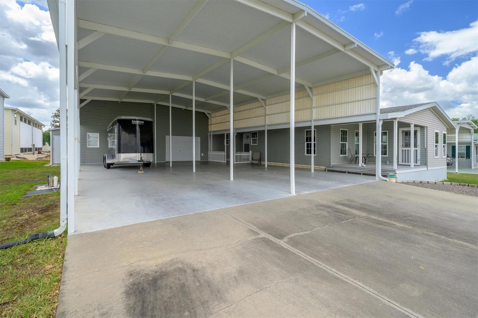 This horse trailer gives you a reference to how tall and large this RV port is.  Currently owner parks a large truck in front of the trailer,  and 2 SUVs fit on the other side.   There are two front entrances from this port.  The main entrance or the front porch entrance. - 10027 EQUITY AVE, DADE CITY