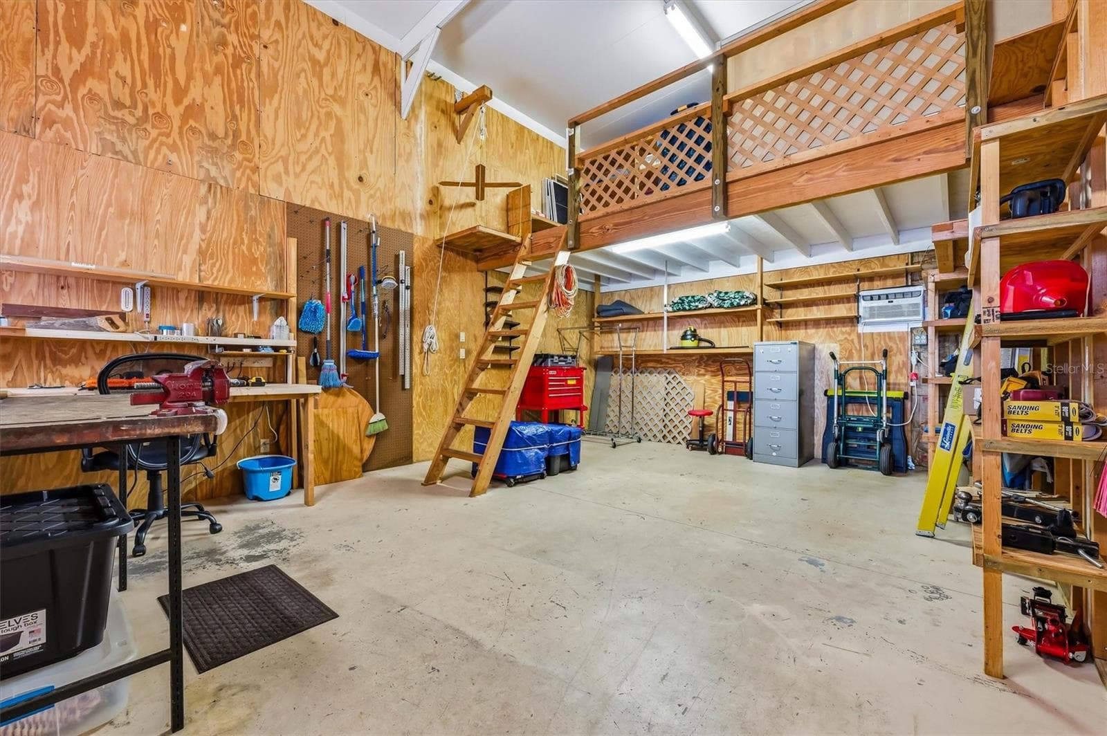 Large workshop with loft for storage, and pulley lift to bring things up.  Shelving remains, generator and 17 ft extension ladder can remain. - 10027 EQUITY AVE, DADE CITY