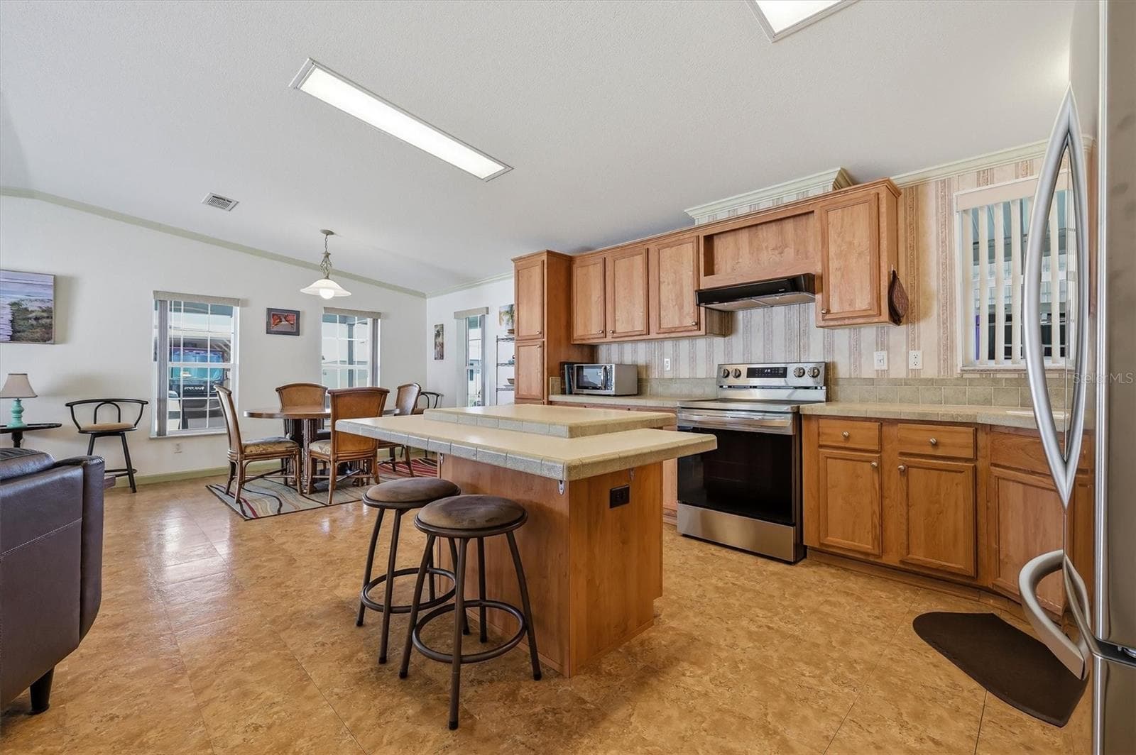 Open kitchen with a lot of cabinets. All appliances remain. - 10027 EQUITY AVE, DADE CITY