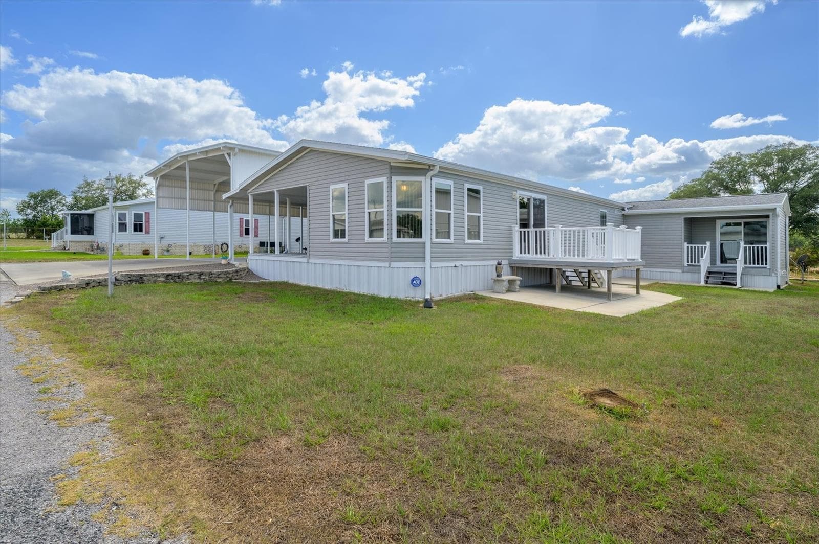 This photo shows large lot with deck from living room,  and then the separate entrance into the flex room currently being used as an office, but which could a den, storage, etc. - 10027 EQUITY AVE, DADE CITY