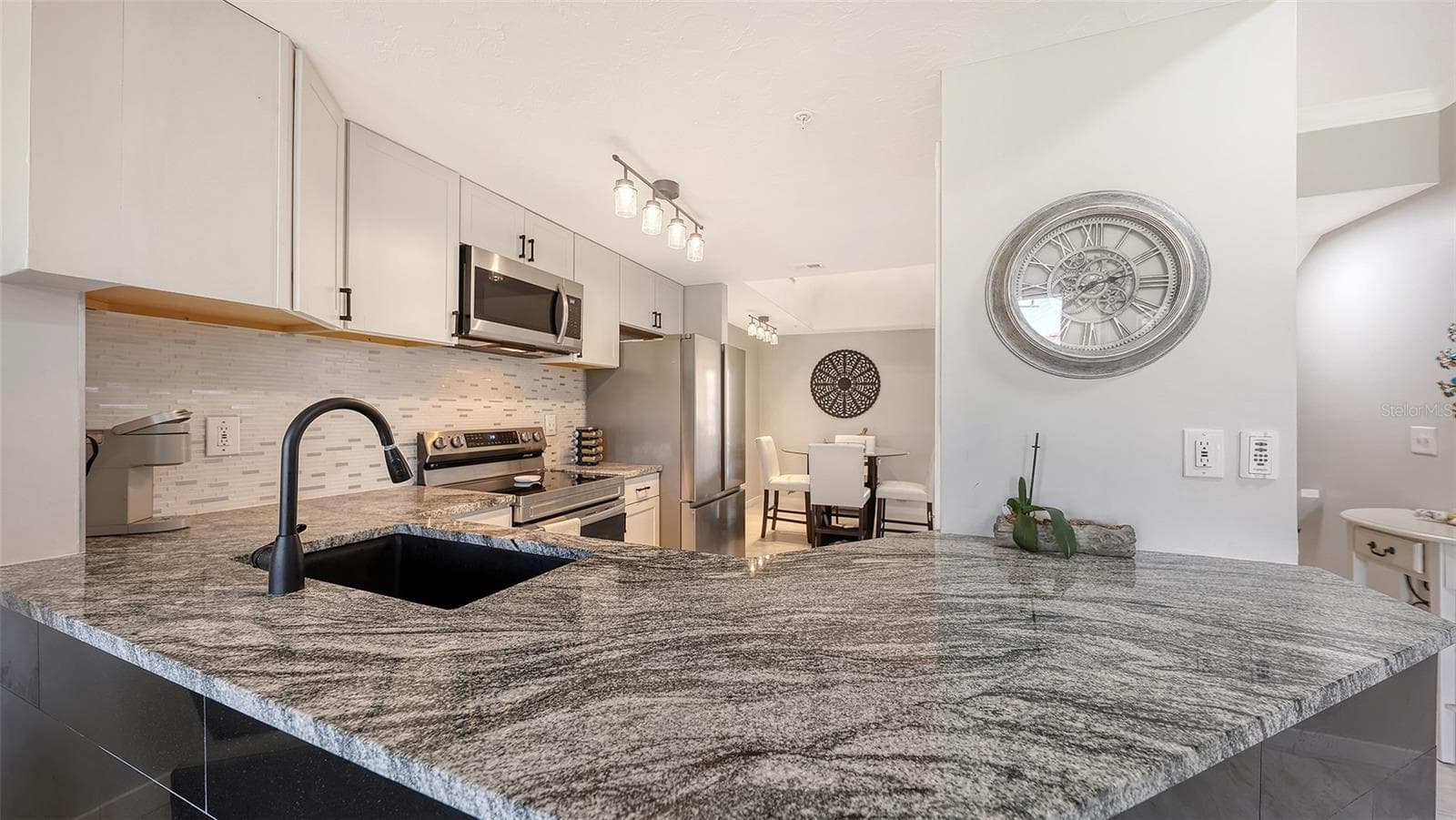 A modern designed kitchen with tile and granite. - 5655 BENTGRASS DR #9-116, SARASOTA