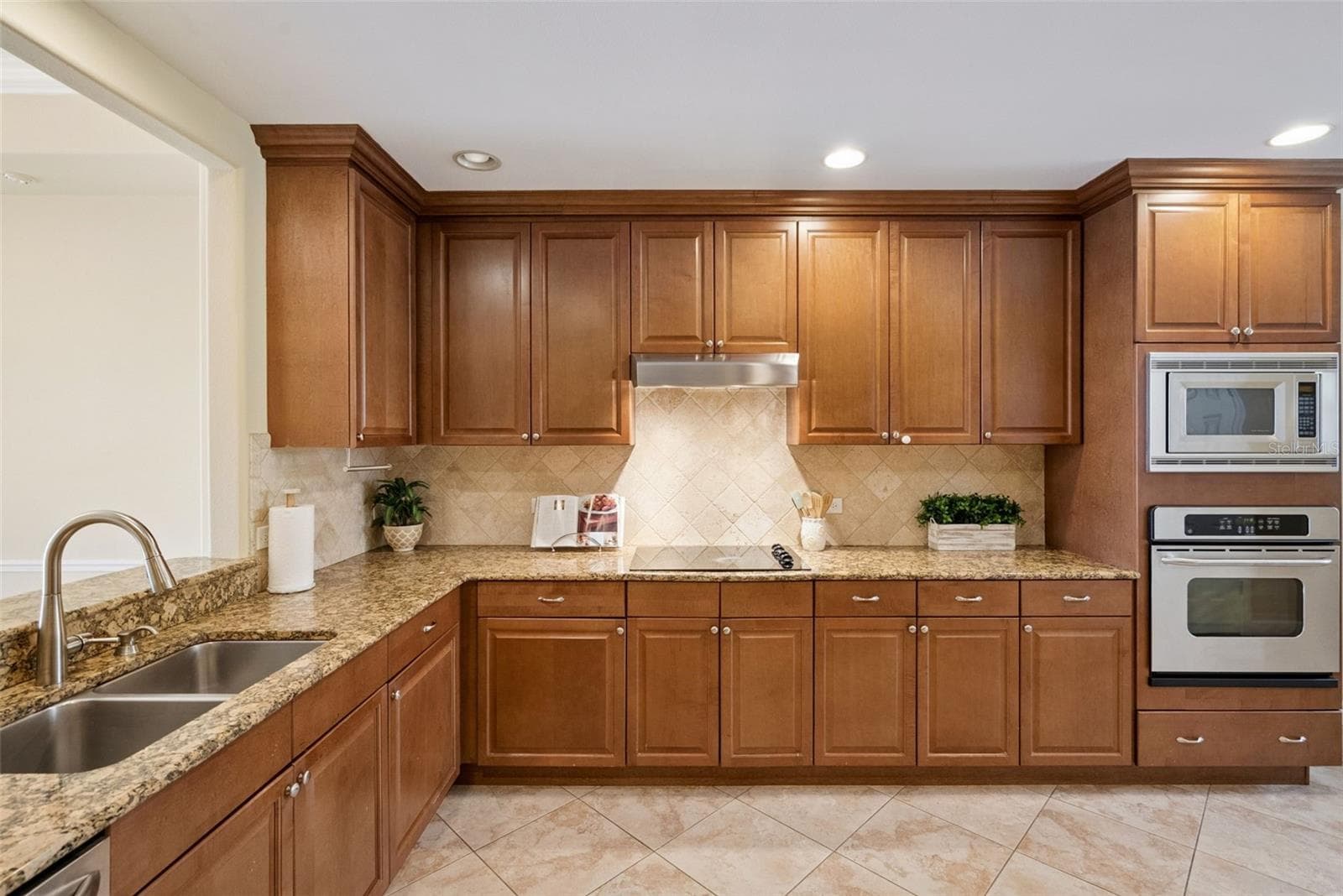 Kitchen with wood cabinetry and granite countertops - 8743 THE ESPLANADE #34, ORLANDO