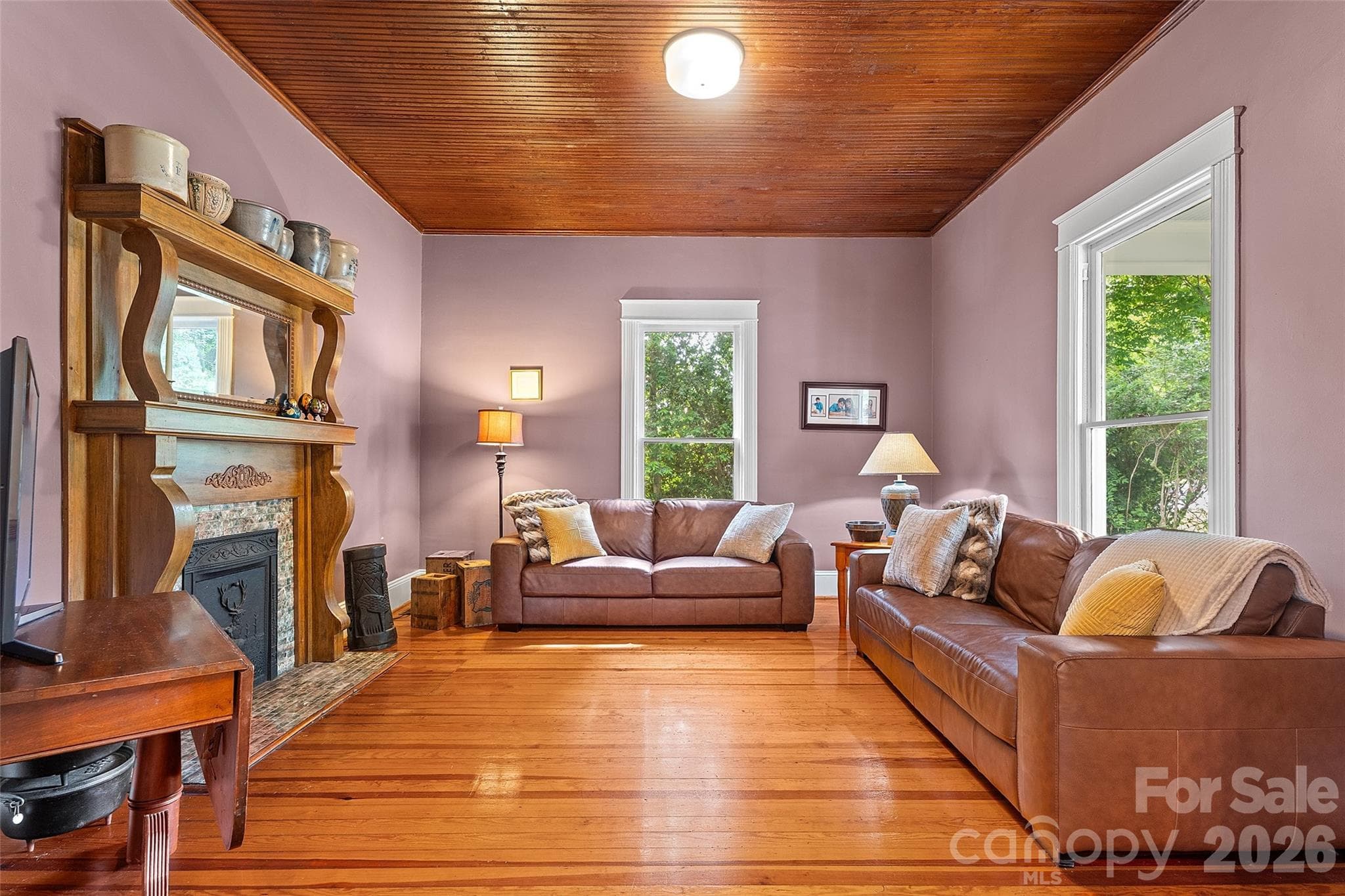 Quaint family room with wood mantel with elegant curved detailing, complemented by a classic tiled surround and decorative cast iron insert—adding timeless character and warmth to the space. - 602 N Main Street, Davidson