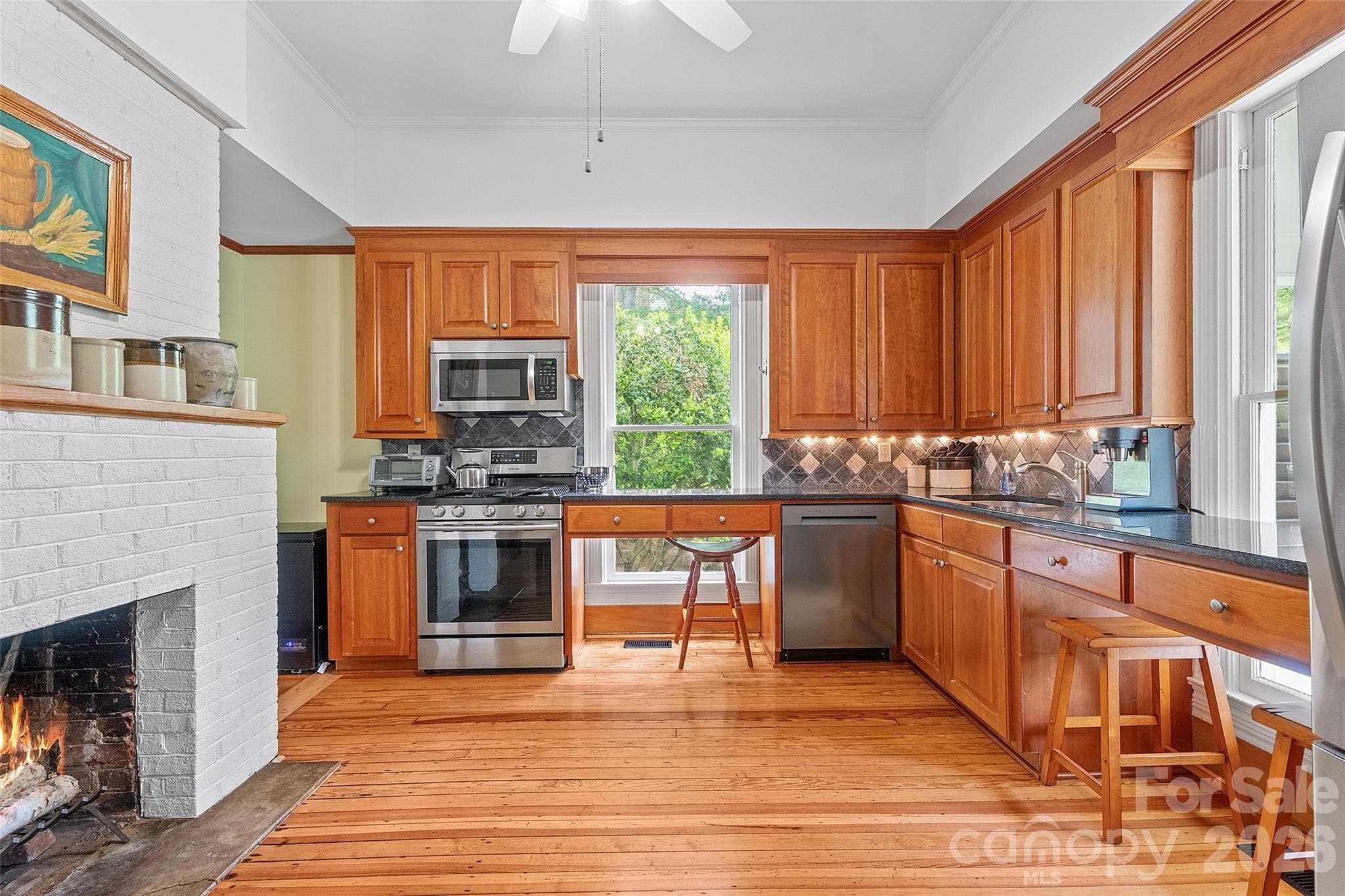 The classically updated kitchen offers high-quality wood cabinetry, granite countertops, and a design that honors the home’s history while supporting modern use. - 602 N Main Street, Davidson