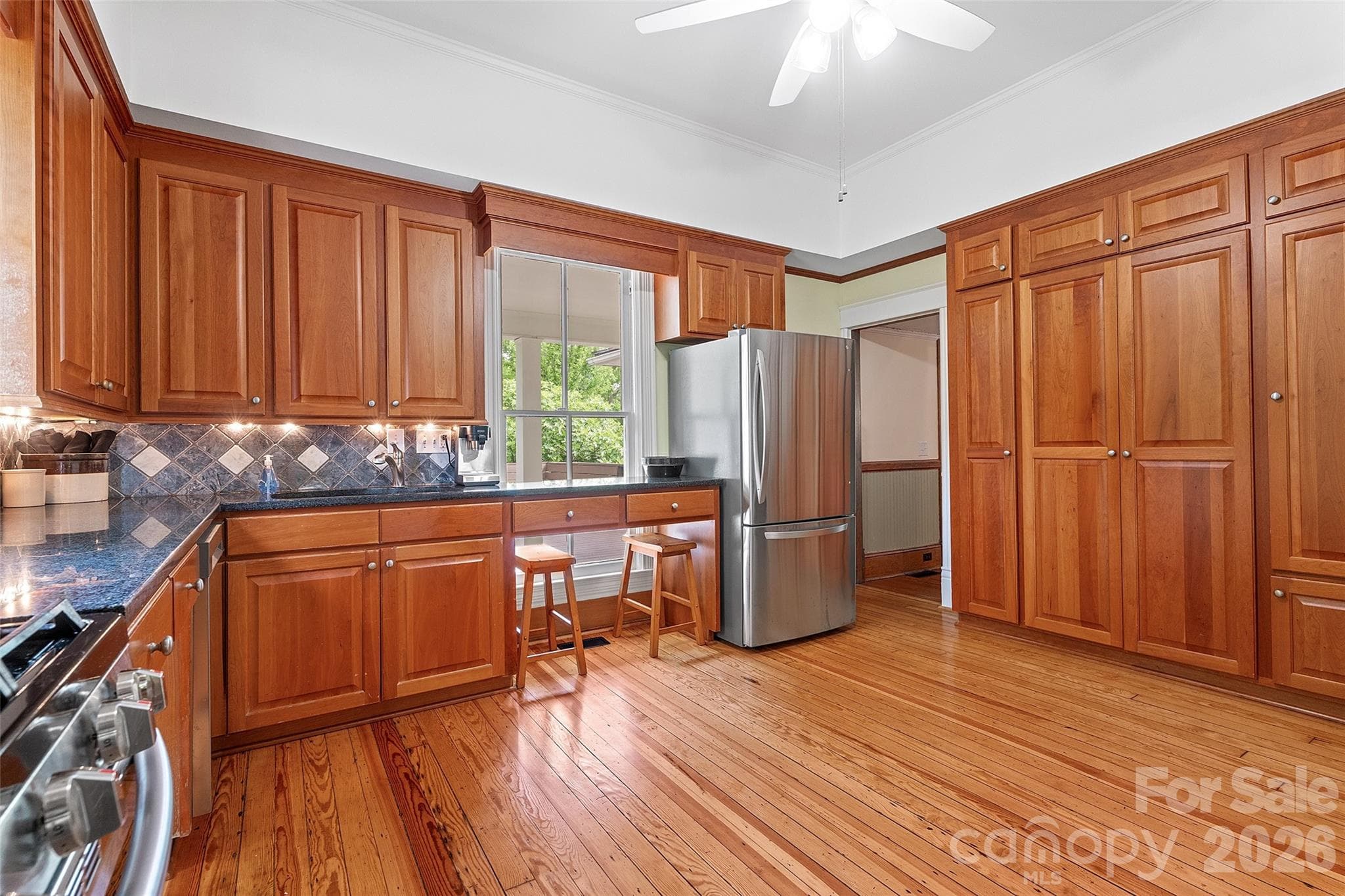 The classically updated kitchen offers high-quality wood cabinetry, granite countertops, and a design that honors the home’s history while supporting modern use. - 602 N Main Street, Davidson