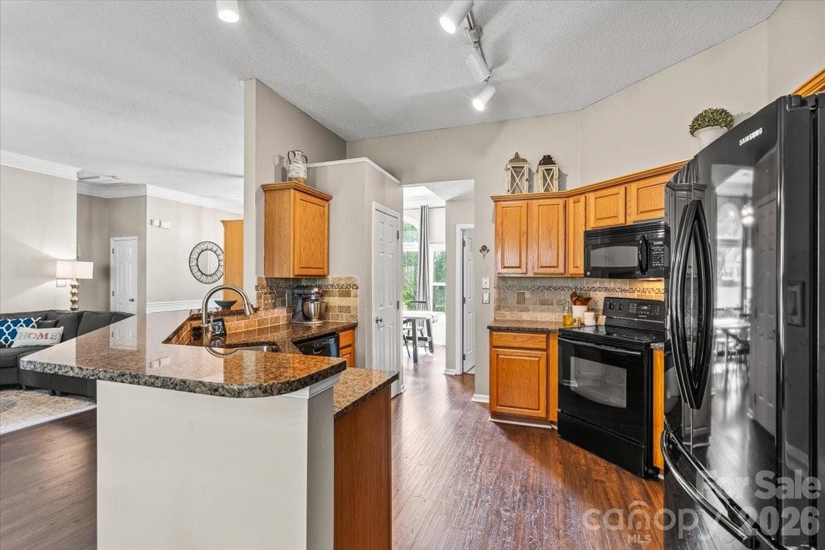 Tile backsplash and a large dual-bowl stainless steel sink keep the kitchen both functional and beautiful - Charlotte