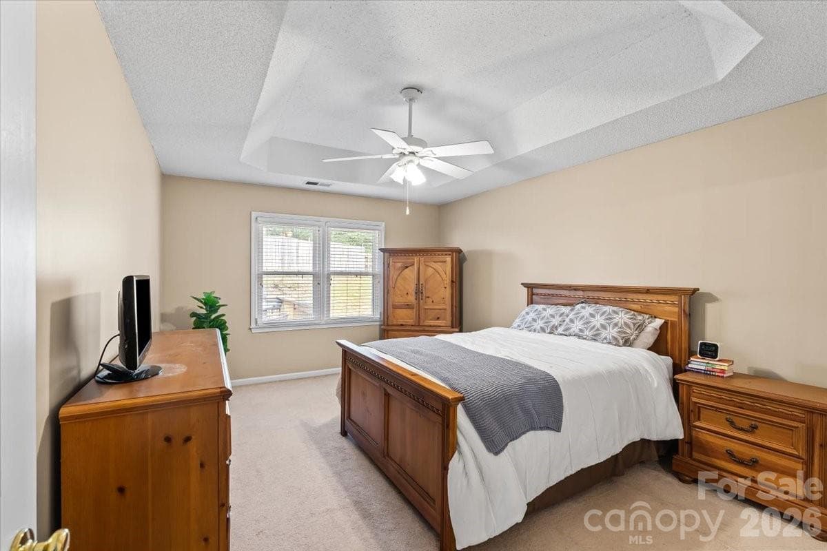 Spacious primary bedroom with tray ceiling, freshly painted in 2026, set privately on its own side of the home - Charlotte