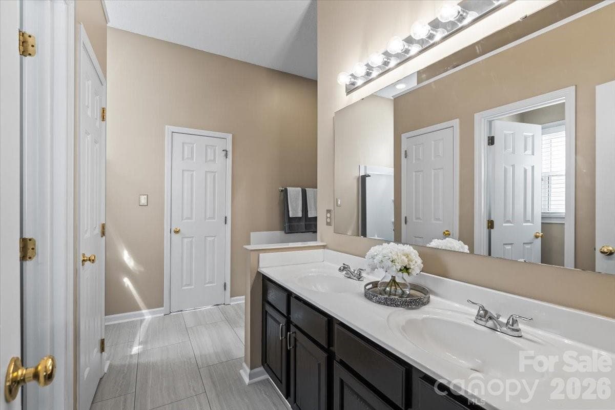 5-piece en suite featuring a garden tub, updated tile shower with frameless glass door, double vanity, a separate water closet and oversized walk-in closet - Charlotte