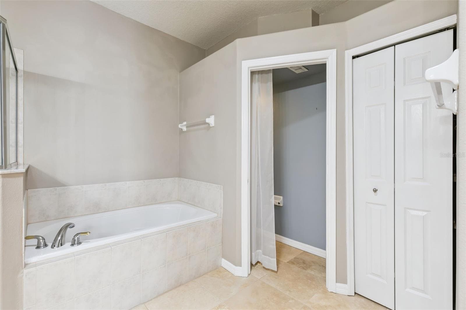 Garden tub and linen closet in primary bathroom. - 237 STRATHMORE CIR, KISSIMMEE
