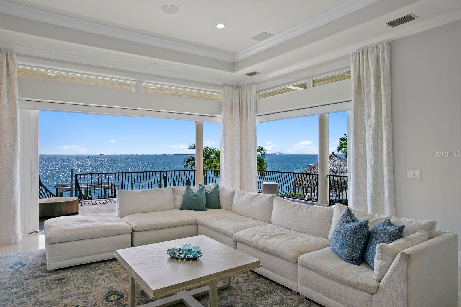 Enjoy stunning waterfront views of Tampa Bay from the family room as the sliding glass doors open completely to the outdoors. - 611 1ST AVE S, TIERRA VERDE