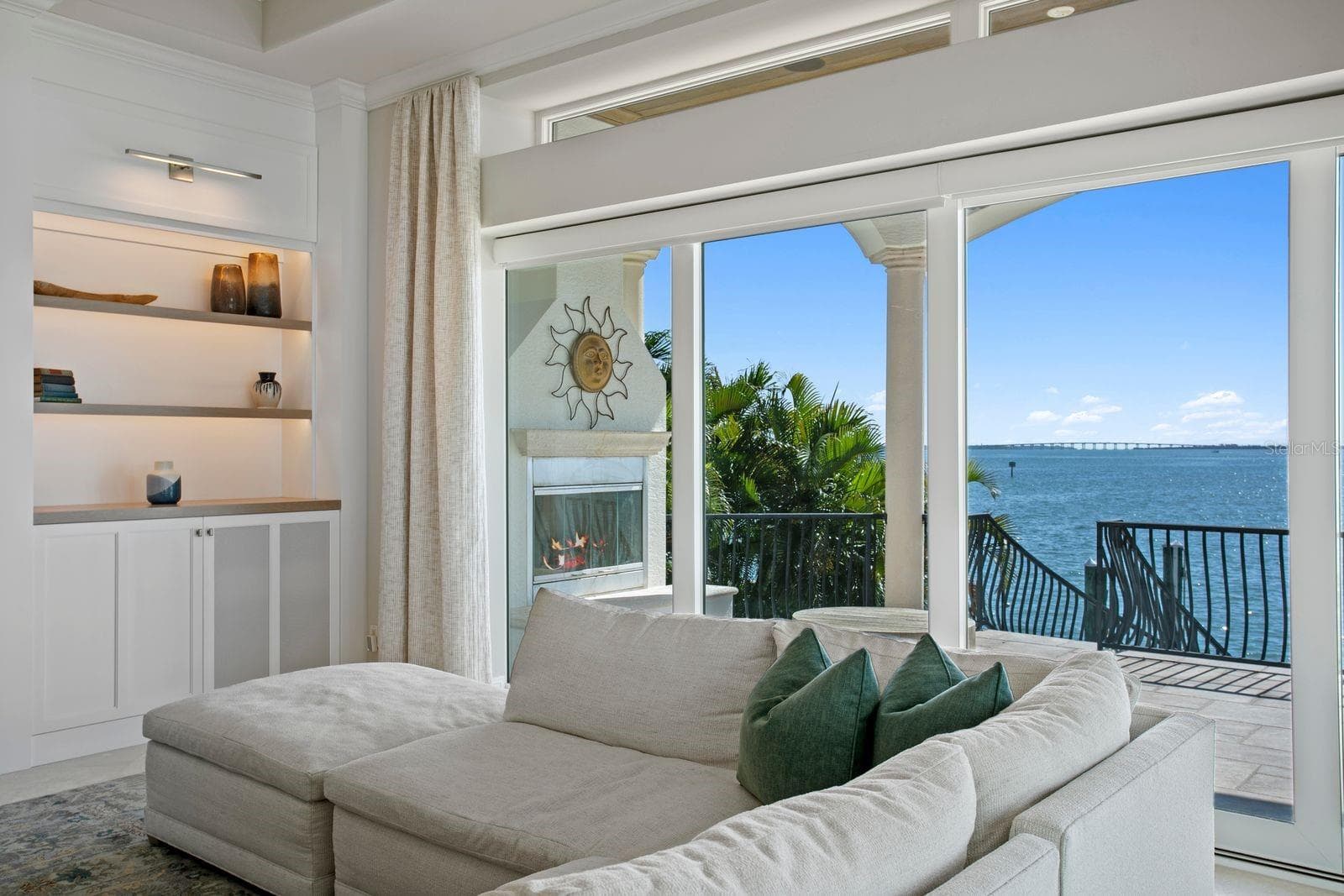 An inviting outdoor fireplace is perfectly positioned on the balcony just beyond the family room. - 611 1ST AVE S, TIERRA VERDE
