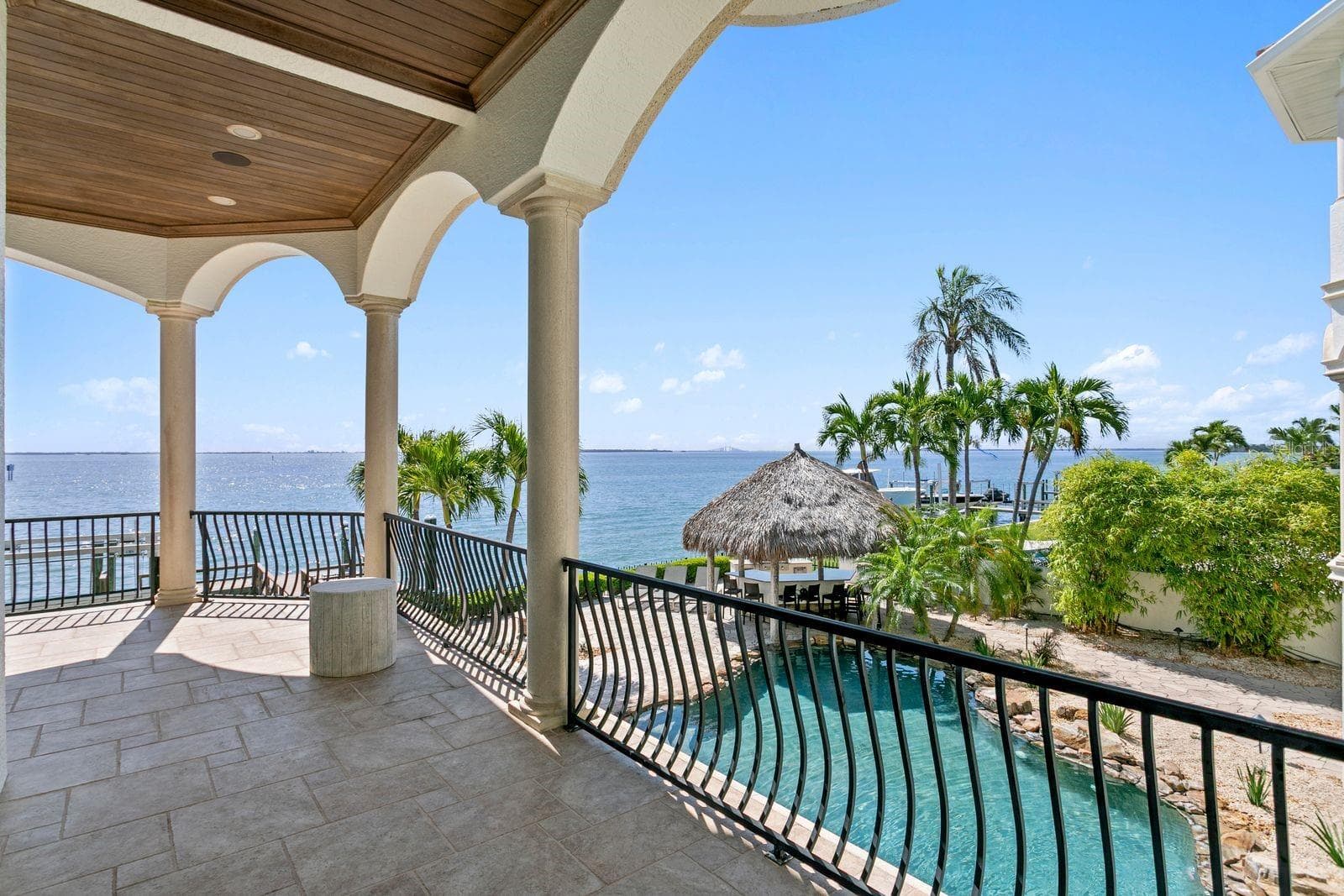 The right side of the balcony just outside the family room, enjoy breathtaking views of Tampa Bay, the pool and the outdoor entertaining space. - 611 1ST AVE S, TIERRA VERDE